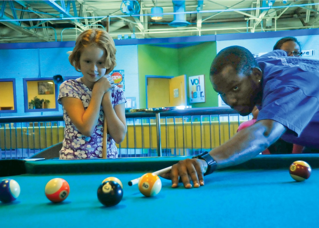 JOINT BASE ANDREWS, Md. -- Brandon Compton, Andrews Youth Center guidance counselor, prepares to take a shot during a leisure game of pool against Emilee Stukerjurgen, 9, during the after hours program, at the Youth Center Sept. 17. Emilee is the daughter of Master Sgt. Doug Stukerjurgen, Headquarters, Air Force Office of Special Investigations financial manager. (U.S. Air Force photo by Bobby Jones)
