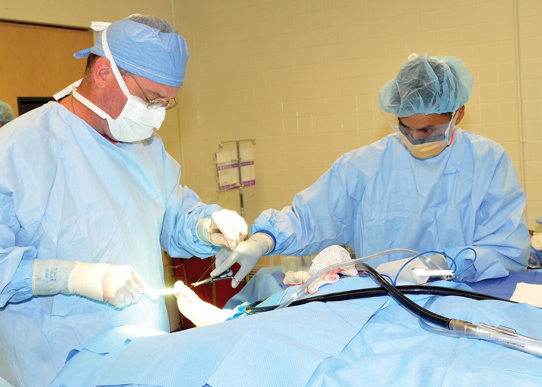 JOINT BASE ANDREWS, Md. -- Senior Airman Bounthai Chanthala, 779th Medical Group surgical technologist, right, assists Lt. Commander (Dr.) Ian McGuiness during a buionectomy surgery at Malcolm Grow Medical Center during National Surgical Technologist Week, sponsored by the Association for Surgical Technologists. The week observes the contribution of surgical technologists from Sept. 19 through 25. (U.S. Air Force photo by Melanie Moore)