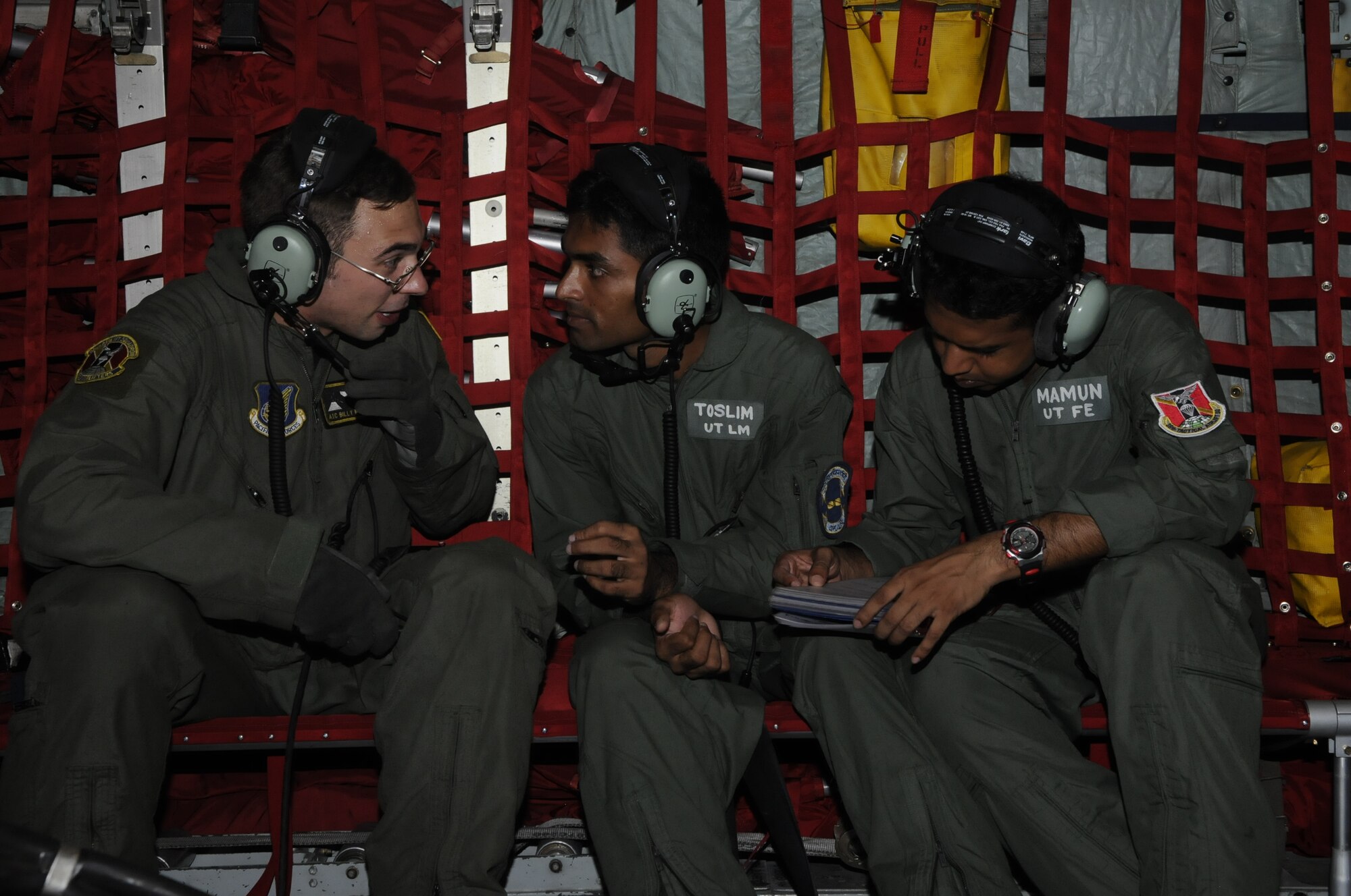 Airman 1st Class William Mehalick, a loadmaster from the 36th Airlift Squadron at Yakota Air Base, Japan, talks to Leading Aircraftsman Toslim, a Bangladesh loadmaster, and Corp. Mamun, a flight engineer, about in-flight procedures during a flight to Sylhet, Bangladesh, on a U.S. C-130 Hercules aircraft during exercise Cope South 10, on Sept. 22, 2010. The bilateral exercise's subject matter expert exchanges in maintenance, operations and rigging disciplines strengthen the strong and growing partnership between the United States and Bangladesh. Two C-130s from Yokota Air Base, Japan, and an AN-32 from Kurmitola Air Base participated in Cope South 10. (U.S. Air Force photo/ Master Sgt. Jeff Loftin)
