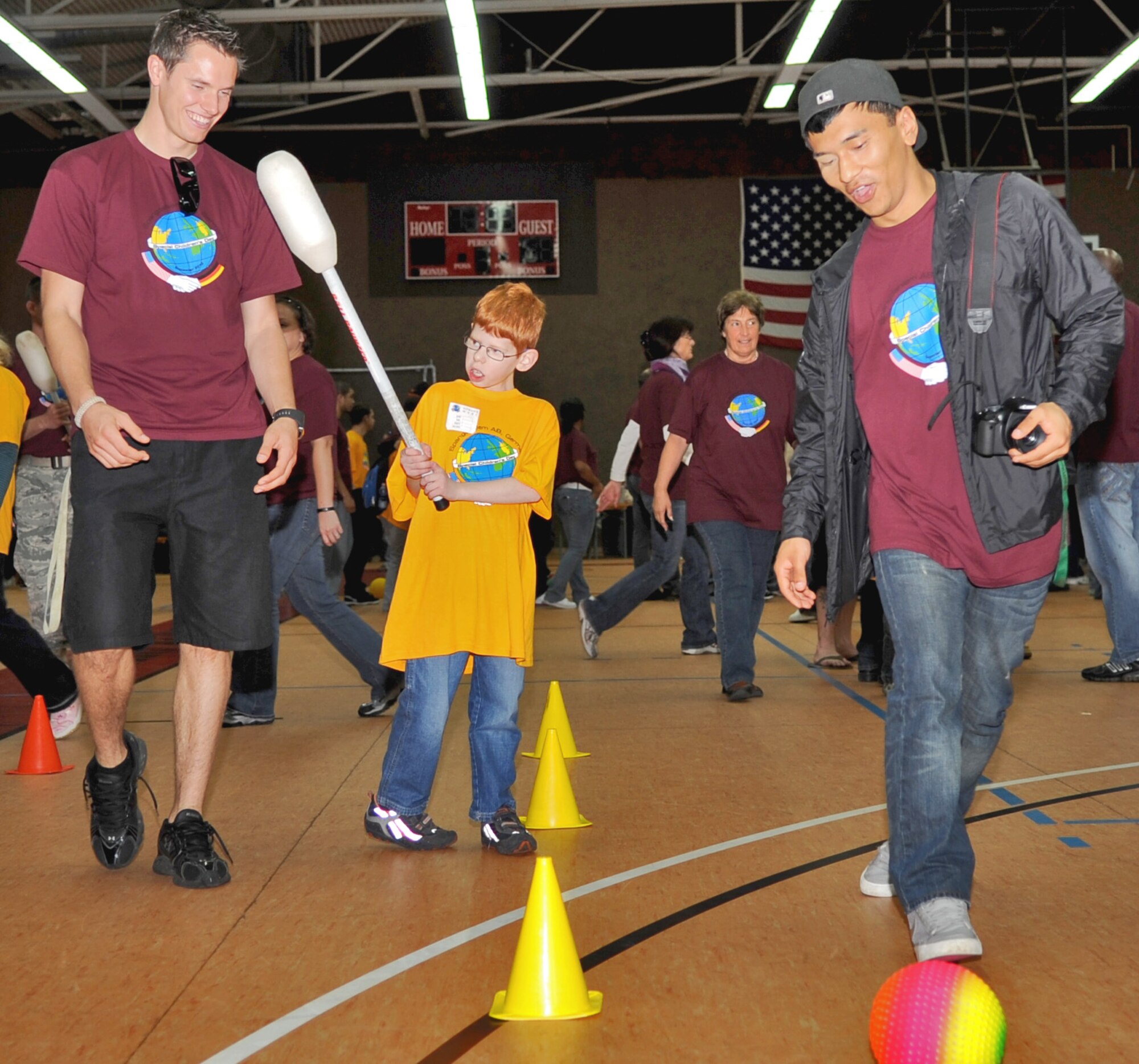 SPANGDAHLEM AIR BASE, Germany – Airman 1st Class Sean Conaway, left, 52nd Civil Engineer Squadron, service contracts journeyman, and Airman 1st Class Tenzin Karbang, 52nd CES heating, ventilating and air conditioning journeyman, help their nine-year-old buddy Mvac Görgen play stickball during St. Martin’s Children’s Day Sept. 23. The event included several individual games, a cookout, a basketball game, and an awards ceremony. (U.S. Air Force photo/Senior Airman Nick Wilson) 