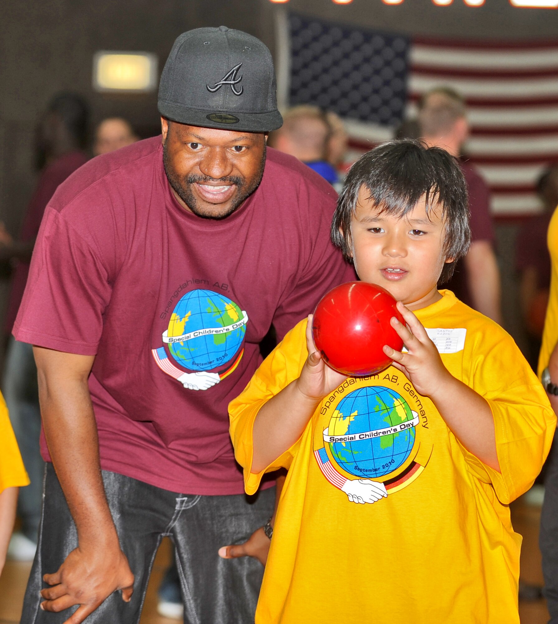 SPANGDAHLEM AIR BASE, Germany – Staff Sgt. Al Moore, 52nd Aerospace Medicine Squadron public health craftsman, helps his seven-year-old buddy Kiden Santos play Scatterball during St. Martin’s Special Children’s Day Sept. 23. The event included several individual games, a cookout, a basketball game, and an awards ceremony. (U.S. Air Force photo/Senior Airman Nick Wilson)