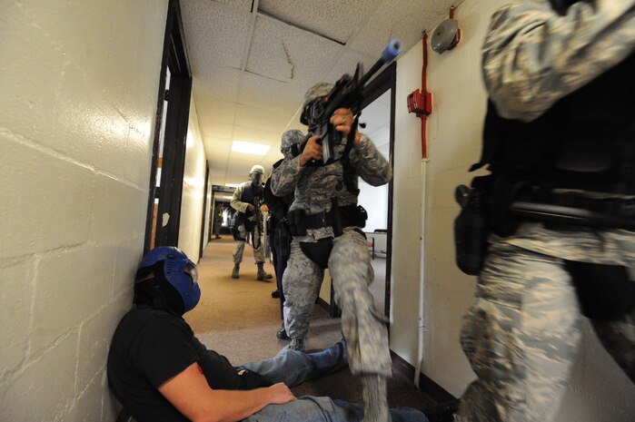 Members of the 628th Security Forces Squadron move through the hallway looking for an aggressor during a mock hostile situation during the active shooter training exercise on Joint Base Charleston, S.C., Sept. 22, 2010. The AST exercise was a joint operation between both Air Force and Navy personnel and tested the deployment of rapid intervention techniques. (U.S. Air Force photo by James M. Bowman/released)