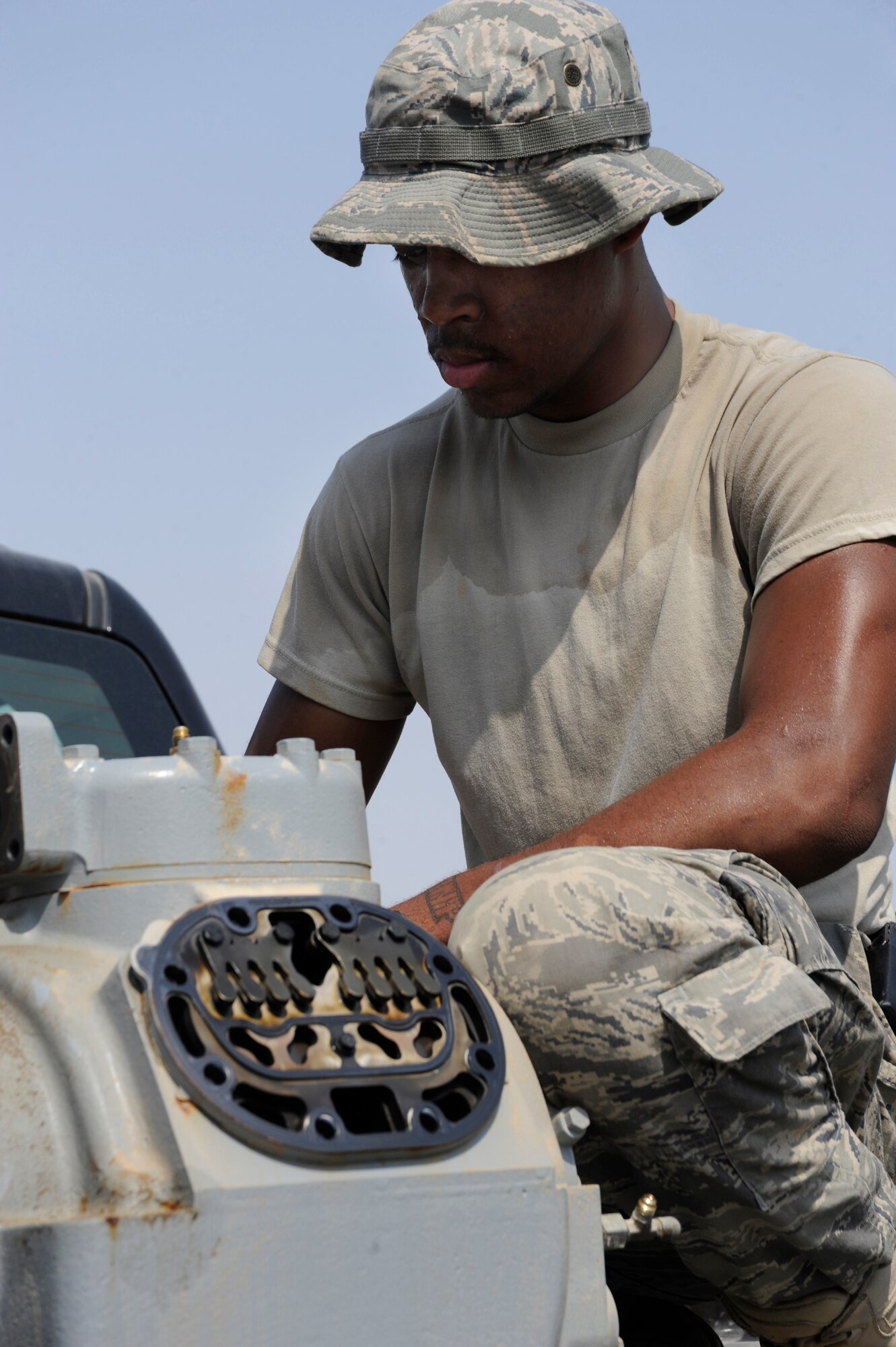 Airman 1st Class LeAndre Davis, 380th Expeditionary Civil Engineer Squadron heating ventilation and air conditioning technician, works on an air conditioner compressor Sept. 23, 2010 at an undisclosed location in Southwest Asia. (U.S. Air Force photo/Tech. Sgt. April Wickes)