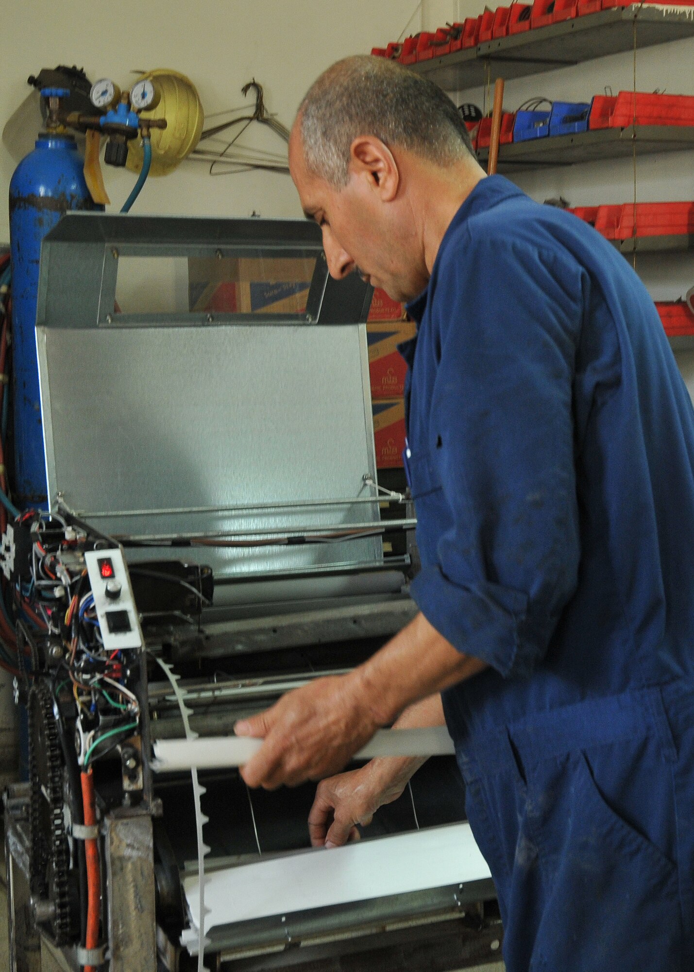Bedir Tanir, Incirlik Fabric Care Facility mechanic, sorts trouser guards from a machine. This machine was created by Mr.Tanir in order to cut costs and contributed to the $131,000 saved by the facility since 2000. (U.S. Air Force Photo/ Senior Airman Alexandre Montes)  