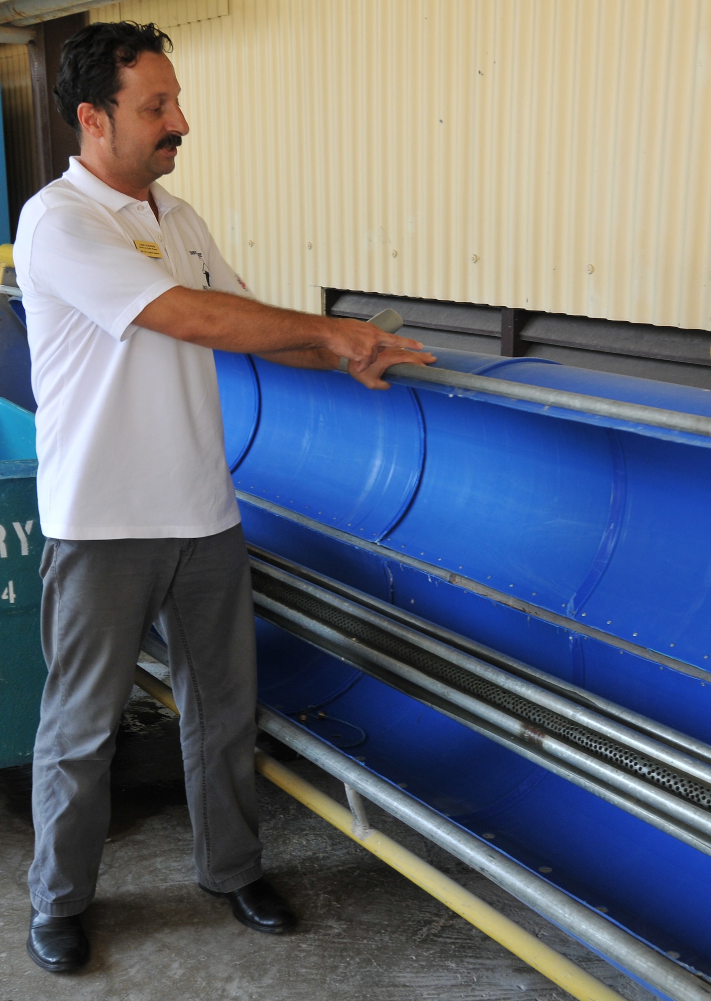 Zafar Cetindemir, Incirlik Fabric Care Facility manager, explains the operation and benefits of the facility’s carpet drying machine Sept. 21, 2010 at Incirlik Air Base, Turkey.  This machine was created by Bedir Tanir, Incirlik FCF mechanic, using recycled parts and contributed to the $131,000 saved by the facility since 2000. (U.S. Air Force Photo/ Senior Airman Alexandre Montes)  