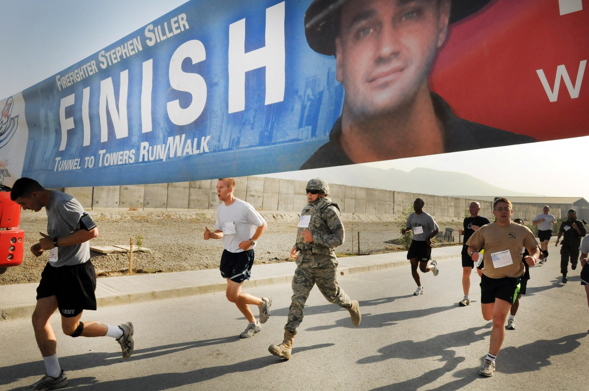 100924-N-6031Q-003 KABUL, Afghanistan - NATO Air Training Command- Afghanistan personnel alongside NATO and civilian partners participate in the "Tunnel to Towers run/walk race on Sep. 24, 2010. The race was held on the International Security Assistance Force and Afghan Air Force base in Kabul, Afghanistan. The race is to commemorate the arduous run made by New York City Firefighter Stephen Siller, who during the events of 9/11 picked up his gear weighing 75 pounds and ran to the twin towers nearly three miles away and perished alongside his fellow firefighters in the attempt to save lives. After the race a piece of steel was placed in a memorial on the grounds of the AAF base where it will stay until the last American leaves Afghanistan. (US Navy photo by Mass Communication Specialist 2nd Class David Quillen/ RELEASED).