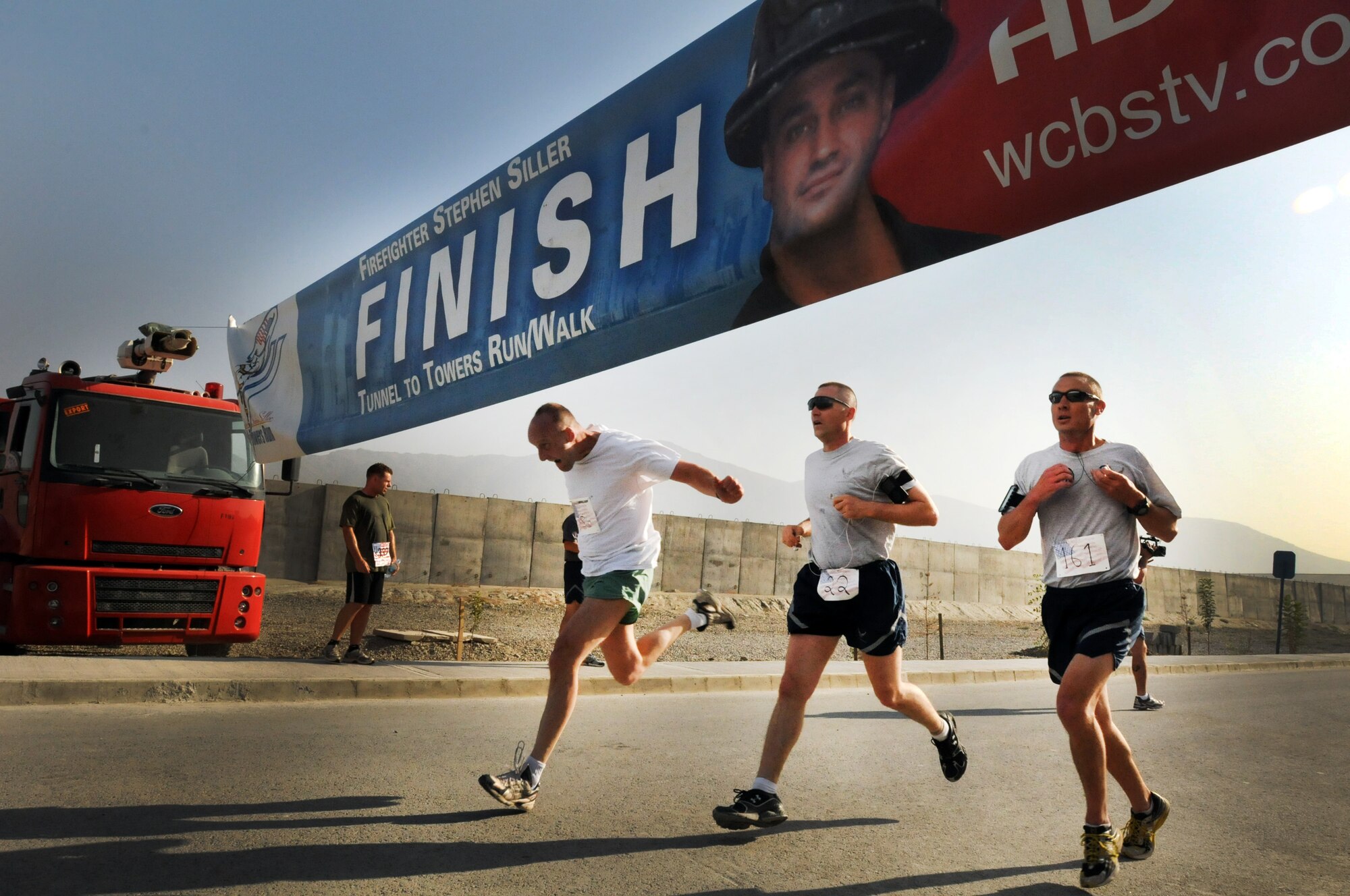 100924-N-6031Q-001 KABUL, Afghanistan - NATO Air Training Command- Afghanistan personnel alongside NATO and civilian partners participate in the "Tunnel to Towers run/walk race on Sep. 24, 2010. The race was held on the International Security Assistance Force and Afghan Air Force base in Kabul, Afghanistan. The race is to commemorate the arduous run made by New York City Firefighter Stephen Siller, who during the events of 9/11 picked up his gear weighing 75 pounds and ran to the twin towers nearly three miles away and perished alongside his fellow firefighters in the attempt to save lives. After the race a piece of steel was placed in a memorial on the grounds of the AAF base where it will stay until the last American leaves Afghanistan. (US Navy photo by Mass Communication Specialist 2nd Class David Quillen/ RELEASED).