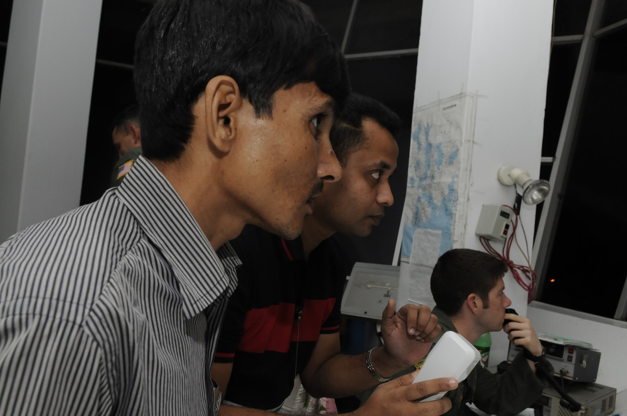 SYLHET AIRPORT, BANGLADESH - Mahbub Imtiaj, Mashiur Rahaman and Capt. Andrew

Bower watch a U.S. C-130 Hercules taxi from the control tower at Sylhet

airport, Bangladesh, during exercise Cope South 10, Sept. 22, 2010. Captain

Bower, 36th Airlift Squadron, was a tower liaison at the airport during the

bilateral exercise. Cope South 10 offered 40 Airmen from Yokota Air Base,

Japan, the opportunity to exchange airlift, air land and airdrop delivery

techniques with the Bangladesh Air Force. Two C-130s from Yokota Air Base,

Japan, and an AN-32 from Kurmitola Air Base participated in the exercise.(U.S, Air Force photo by Master Sgt. Jeffery Loftlin)

