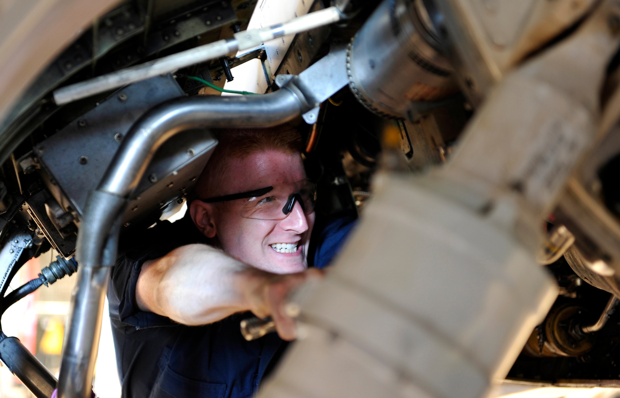 Airman 1st Class Jeremy Straub, 35th Maintenance Squadron crew chief, unscrews a bolt to remove of the A-system hydraulic pressure lines on an F-16 Fighting Falcon, Sept. 22, 2010, at Misawa Air Base, Japan. The jet was in for routine maintenance. (U.S. Air Force photo by Staff Sgt. Chad C. Strohmeyer/Released)