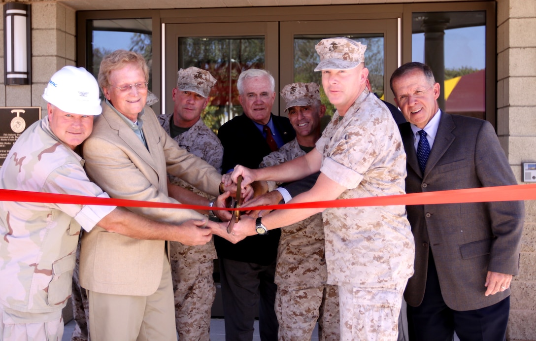 (Left to right) Navy Capt. Michael Williamson, officer in charge of construction, Marine Corps Installations West; Richard Straub, CEO, Straub Construction; Col. Kevin T. Wooley, commanding officer, School of Infantry West; Col. James Williams (ret.), commanding officer, SOI West from 1985-1988; Col. Nicholas F. Marano, commanding officer, Marine Corps Base Camp Pendleton; Col. Brennan T. Byrne, commanding officer, SOI West from 2008-2010; Col. Lee Farmer (ret.), commanding officer, SOI West from 1996-1998; and hidden from view is Sgt. Maj. Bradley A. Kasal, SOI West, and Col. Dennis Judge (ret.), commanding officer, SOI West from 2000-2002, all cut the ceremonial ribbon of SOI’s new command post. The 25,000 square foot building replaces the former headquarters that were housed in 66-year-old Quonset huts.