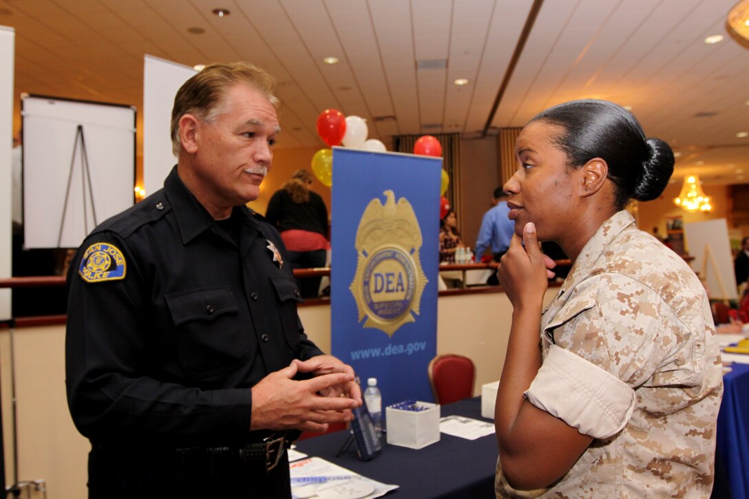 Police Officer Doug Boales, recruiter, San Jose Police Department, talks to Sgt. Tratia Brown, careers and education counselor, Wounded Warrior Battalion West, Camp Pendleton, during Family Member Employment Assistance Program’s biannual Career Fair at Camp Pendleton’s South Mesa Club, Sept. 24. The event sponsored by Marine Corps Community Services, had more than 120 businesses that provided information about local and national career opportunities for job seekers.