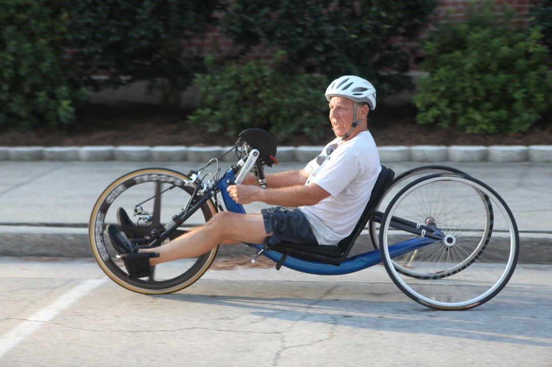 Bruce Newman, a handcyclist, glides his bike near the sidewalk after crossing the finish line at the Marine Corps Community Services’ 24th annual Marine Corps Half Marathon aboard Marine Corps Base Camp Lejeune, Sept. 25.  Handcycling is a sport that allows athletes to ride a bike, mainly using upper body strength and dexterity.