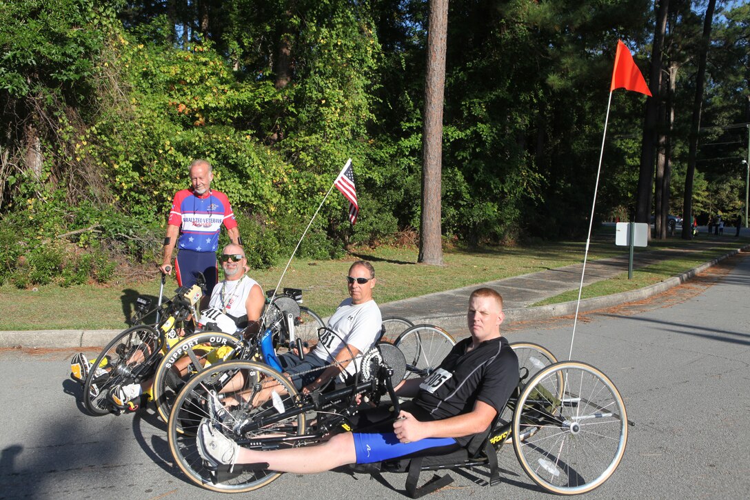 (From left to right) Handcyclists David Swaim, Paul Kelly, Bruce Newman and Sgt. Ryan Anderson pose for a group photo after completing the Marine Corps Community Services’ 24th annual Marine Corps Half Marathon aboard Marine Corps Base Camp Lejeune, Sept. 25.  Handcyclists travel all around the country, competing alongside runners in events such as 10-kilometer races, half marathons and full marathons.