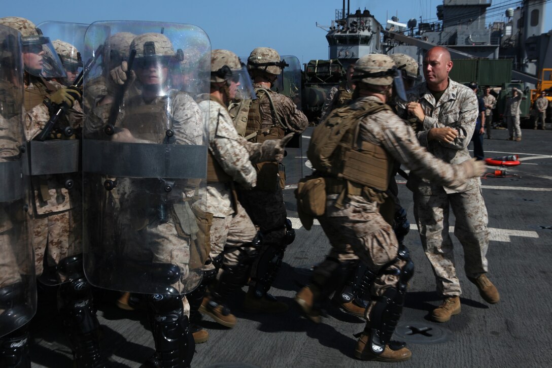 Marines with Company L, Battalion Landing Team 3/8, 26th Marine Expeditionary Unit, practice apprehending a simulated non-compliant person during non-lethal tactics training on the flight deck aboard USS Carter Hall in the U.S. Navy Fifth Fleet Area of Responsibility, Sept. 25, 2010. 26th MEU continues to support relief operations in Pakistan and is also serving as the theater reserve force as elements of the MEU conduct training and planned exercises.