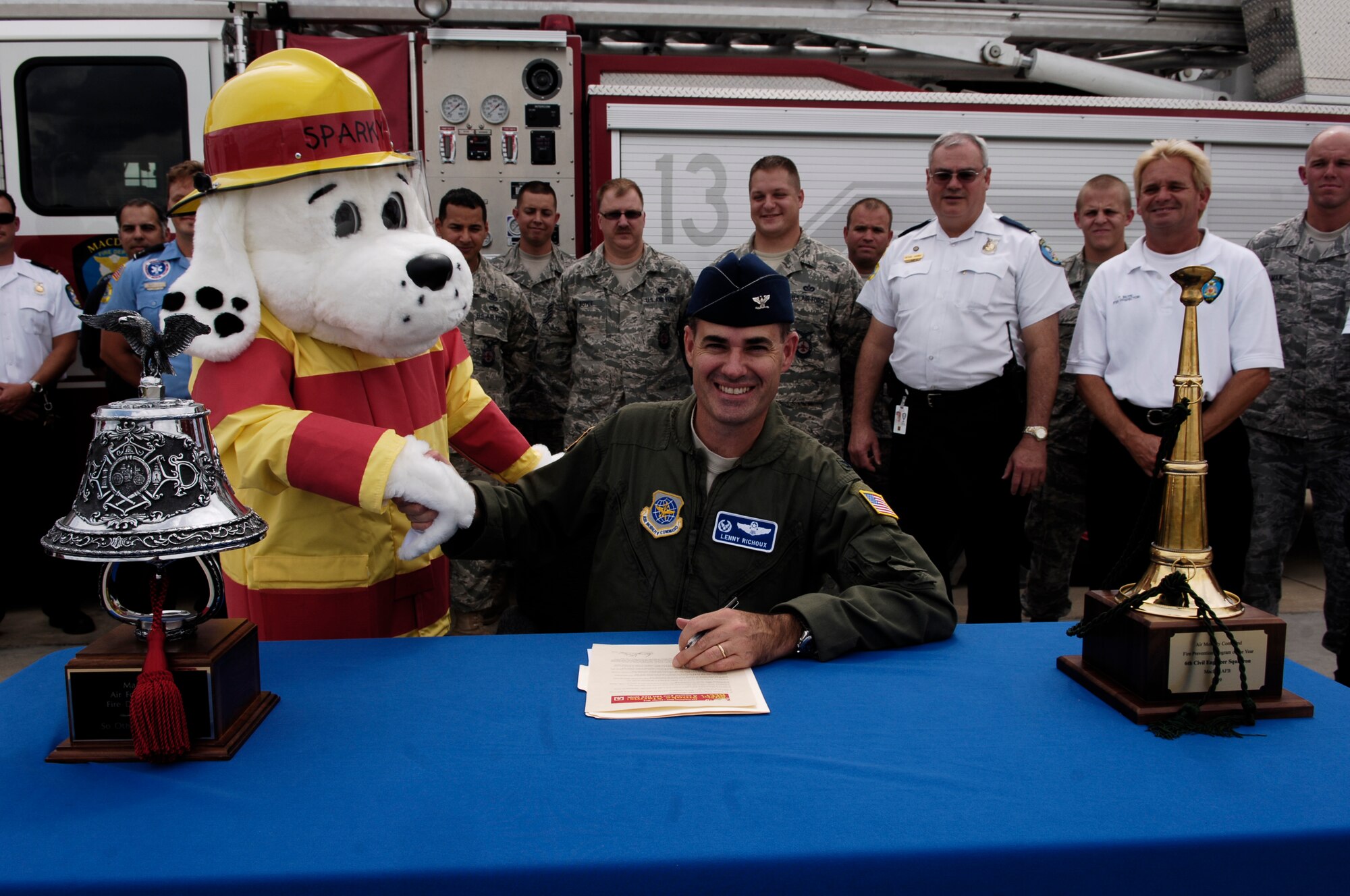 Col. Lenny Richoux, 6th Air Mobility Wing commander, shakes Sparky the Fire Dog's hand after signing the Fire Prevention Week Proclamation Sept. 24, 2010 at the crash fire station on MacDill Air Force Base, Fla. Fire Prevention Week runs Oct. 3 through Oct. 9. (U.S. Air Force photo by Master Sgt. Richard Kaminsky)
