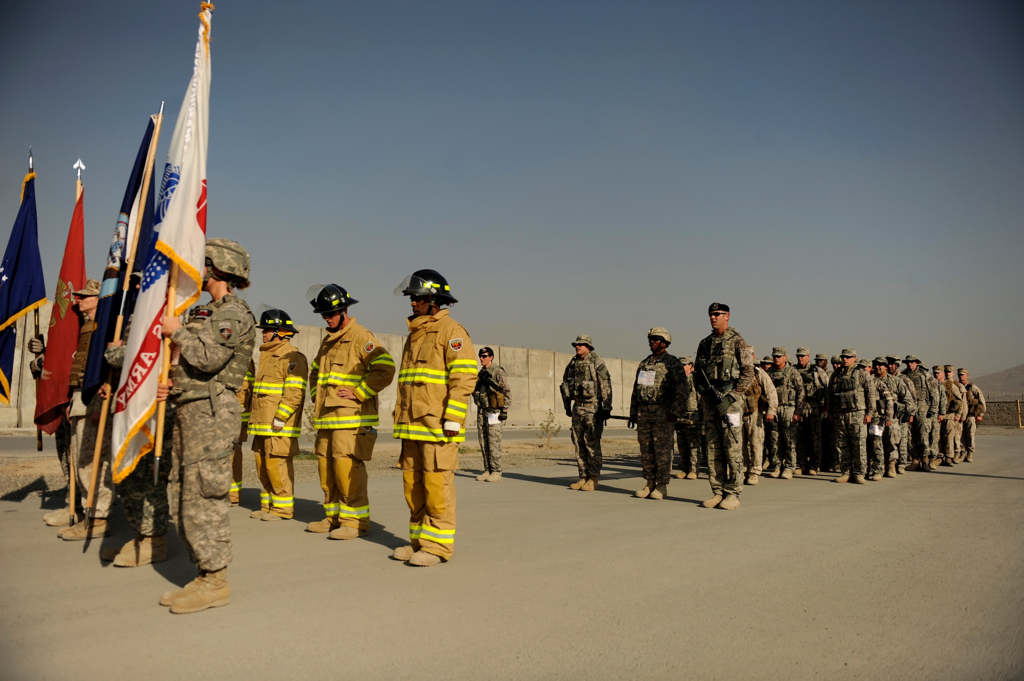 U.S. Soldiers, Sailors, Marines and Airmen get into formation before the last leg of The Firefighter Stephen Siller Tunnel to Towers 5k Run/Walk at Kabul International Airport, Afghanistan, Sept. 24, 2010.  The four branches of the military joined together in one formation to finish carrying the U.S. Flag and a litter carrying a piece of wreckage from the World Trade Center.  (U.S. Air Force Photo/Staff Sgt. Eric Harris) (RELEASED)