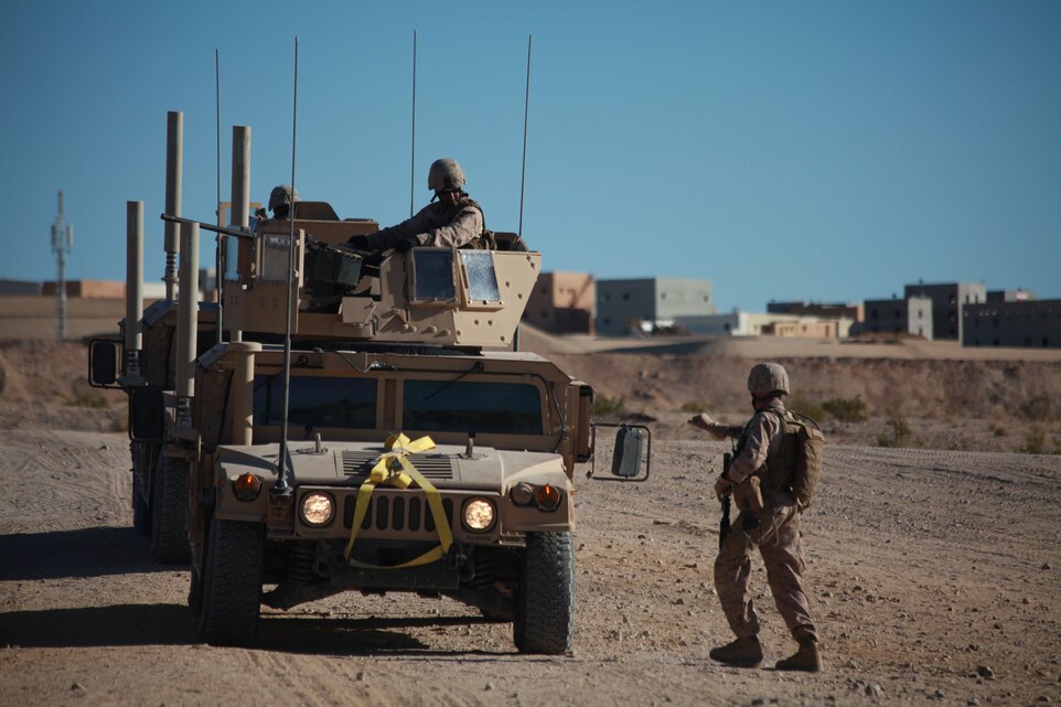 A Marine training with the Combat Center’s Advisor Training Group signals to his vehicle to pull forward while setting up for convoy operations Sept. 27 here. The motorized operations course is a live-fire training event. (Photo by: Lance Cpl. M. C. Nerl)