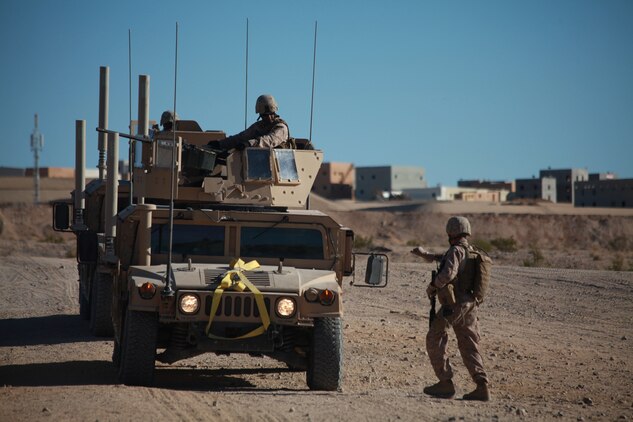 A Marine training with the Combat Center’s Advisor Training Group signals to his vehicle to pull forward while setting up for convoy operations Sept. 27 here. The motorized operations course is a live-fire training event. (Photo by: Lance Cpl. M. C. Nerl)