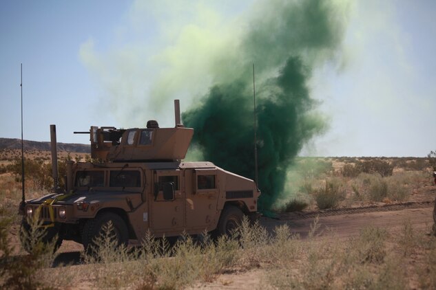 Marines training with the Combat Center’s Advisor Training Group set off signal smoke Sept. 27 after being hit by a notional improvised explosive device. The group trains Marines in convoy operations, which is among many other things they will use in support of Operation Enduring Freedom. (Photo by: Lance Cpl. M. C. Nerl)::r::::n::