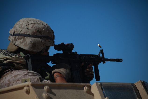 Corporal Maulalo Cortez, a rifleman from Company G, 2nd Battalion, 4th Marine Regiment, takes shots at enemy targets here Sept. 27 during convoy operations live-fire training at Combat Center Range 220.  The Combat Center’s Advisor Training Group trains Marines like Cortez to get them prepared to train Afghan forces. (Photo by: Lance Cpl. M. C. Nerl)::r::::n::