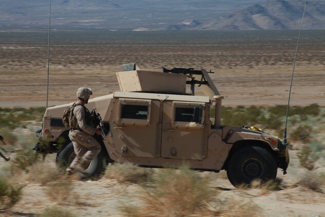 Marines training with the Combat Center’s Advisor Training Group rush up to use their vehicle as cover Sept. 27 at Combat Center Range 220. The group trains Marines in convoy operations, which is among many other things they will use in support of Operation Enduring Freedom.