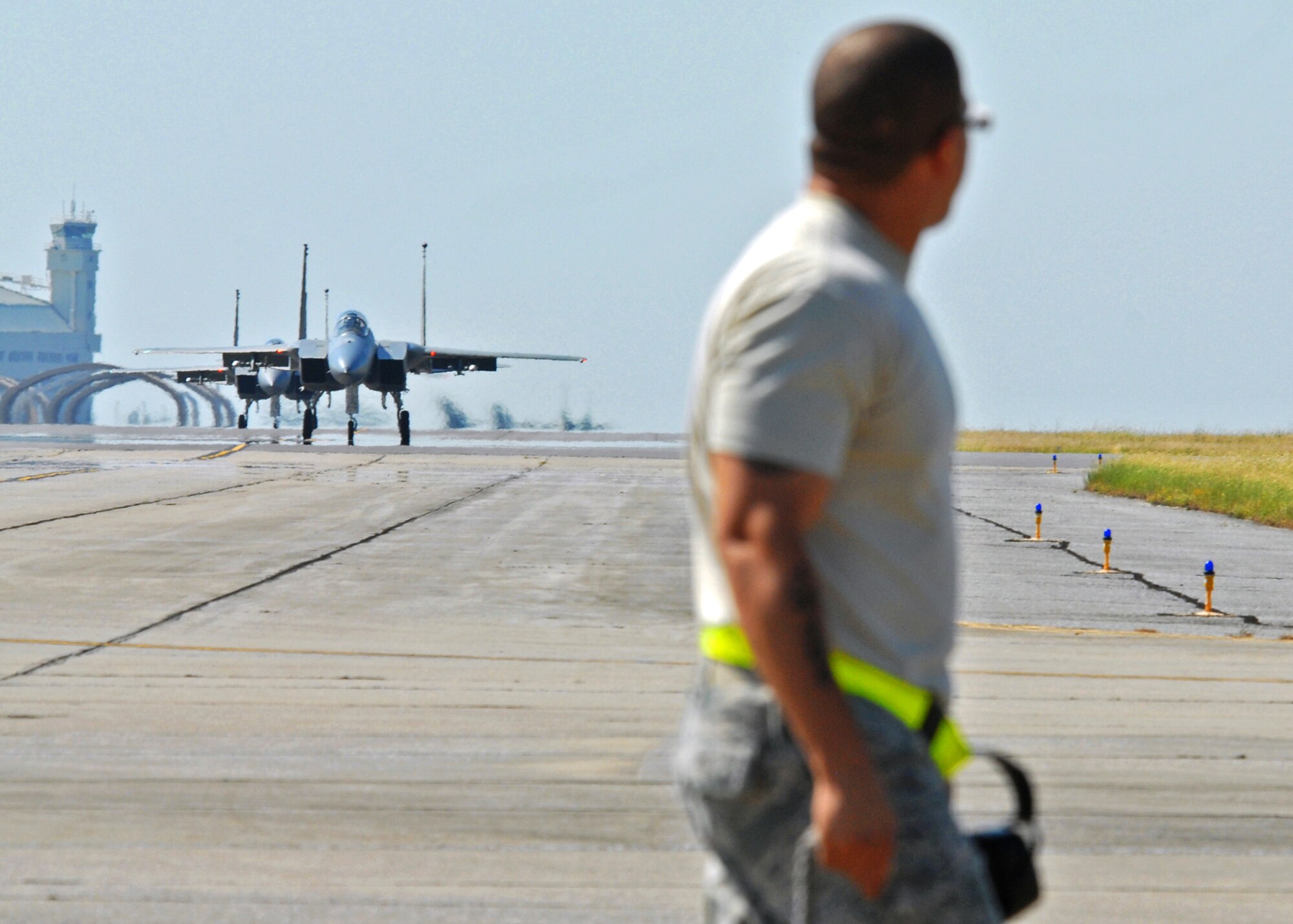 A 46th Test Wing maintainer watches as 53rd Wing F-15s taxi toward him at Eglin Air Force Base, Fla.  More than 1,000 personnel of the 46th Maintenance Group are responsible for maintenance procedures for all of the 46th and 53rd aircraft located at Eglin.  (U.S. Air Force photo/Samuel King Jr.) 