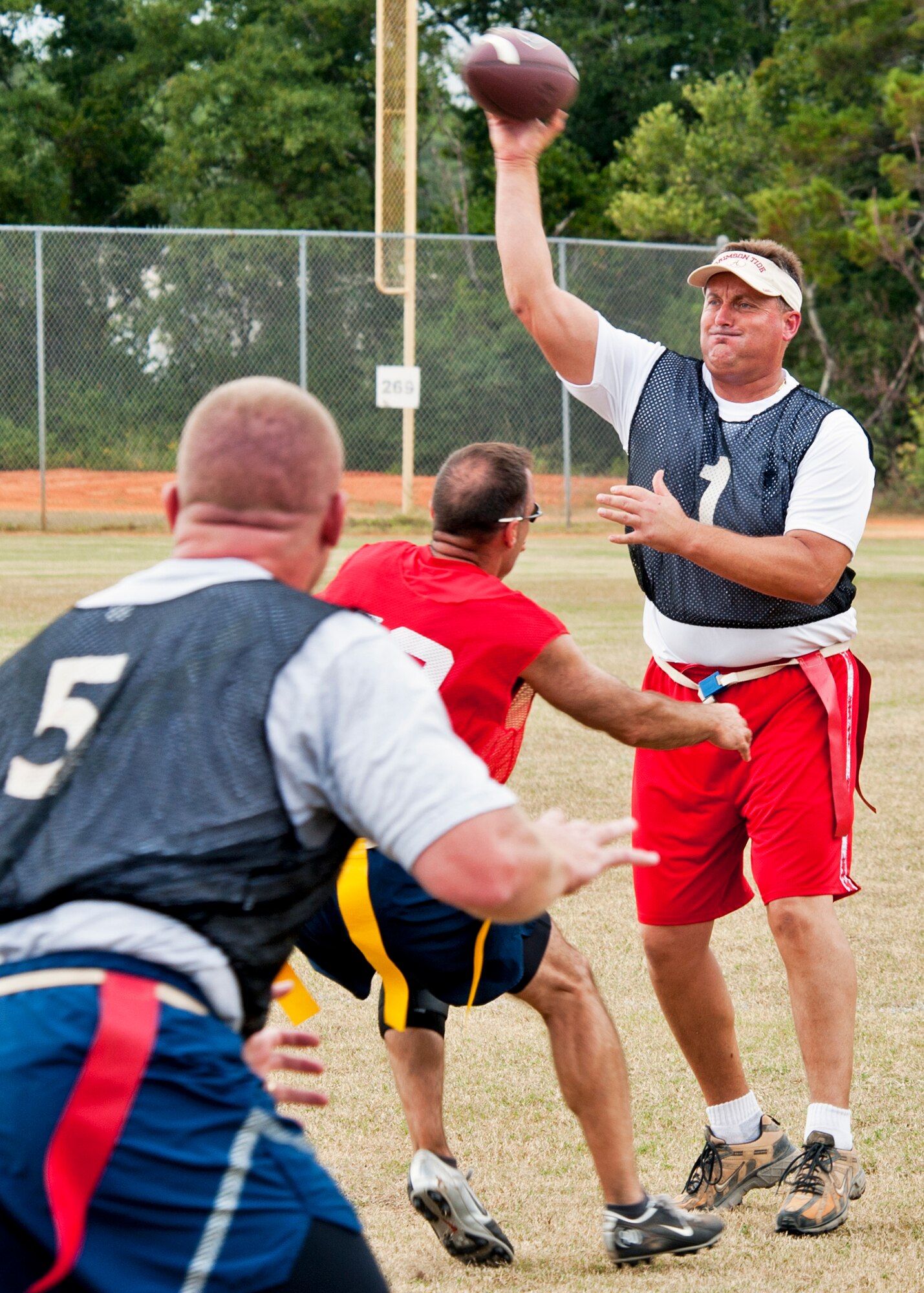 Chief Master Sgt. Donnie Morris, 46th Aircraft Maintenance Squadron, throws a short pass as the defense comes in during the Chiefs vs Eagles flag football game Sept. 24 at Eglin Air Force Base, Fla.  The Chiefs crushed the Eagles 34-13.  Chief Morris threw five touchdown passes in the game.  (U.S. Air Force photo/Samuel King Jr.)