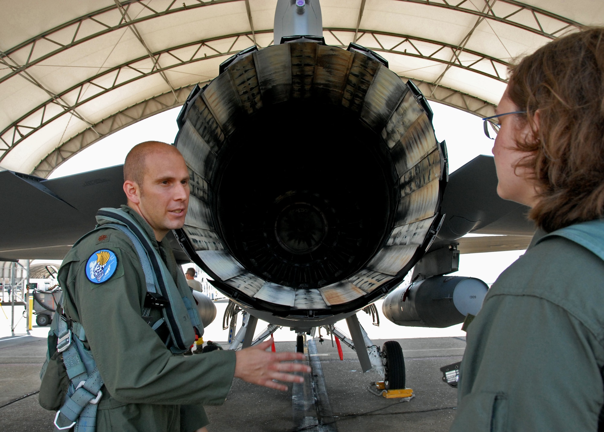 Maj. Kevin Lord, 85th Test and Evaluation Squadron, explains the F-16 engine to a spouse prior to a taxi ride Sept. 24 at Eglin Air Force Base, Fla.  The ride was part of 85th's Spouse Taxi Day event.  Spouses were given tours and training before suiting up for a taxi ride in an F-16.  A few spouses also received a ride in a vintage T-6 courtesy of the 85th's honorary commander, Joe Fagundes.  (U.S. Air Force photo/Samuel King Jr.)