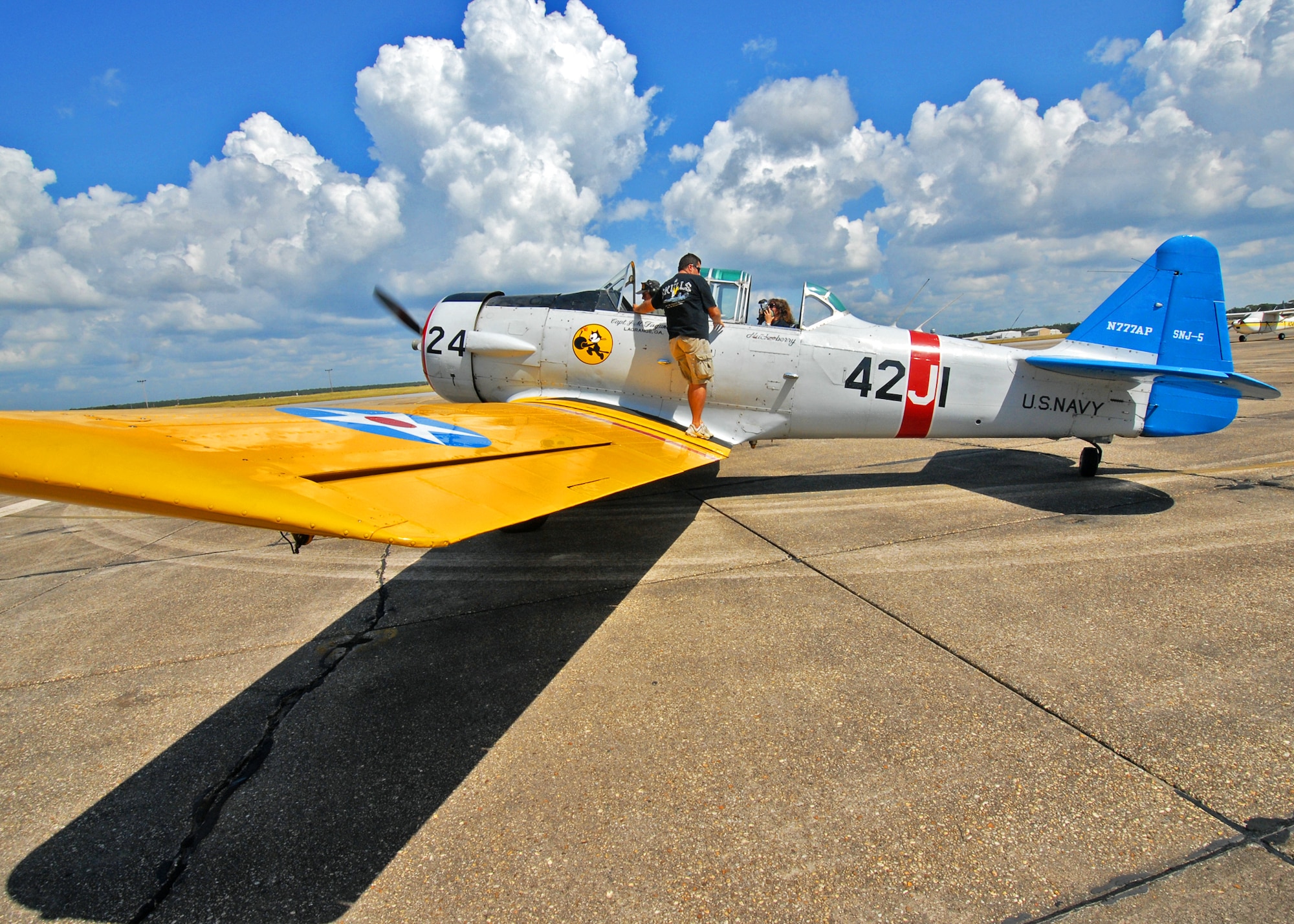 Joe Fagundes, 85th Test and Evaluation Squadron honorary commander, talks with Erica Gantt, after her flight in a T-6 Sept. 24 at Eglin Air Force Base, Fla.  Mrs. Gantt, wife of Col. Michael Gantt, 53rd Wing commander, was the first of many spouses to receive T-6 rides as part of the 85th's Spouse Taxi Day event.  Mr. Fagundes' father, Joe Sr., chauffeured the spouses around the Eglin skies in his vintage aircraft.  Spouses were given tours and training before suiting up for a taxi ride in an F-16.  (U.S. Air Force photo/Samuel King Jr.)