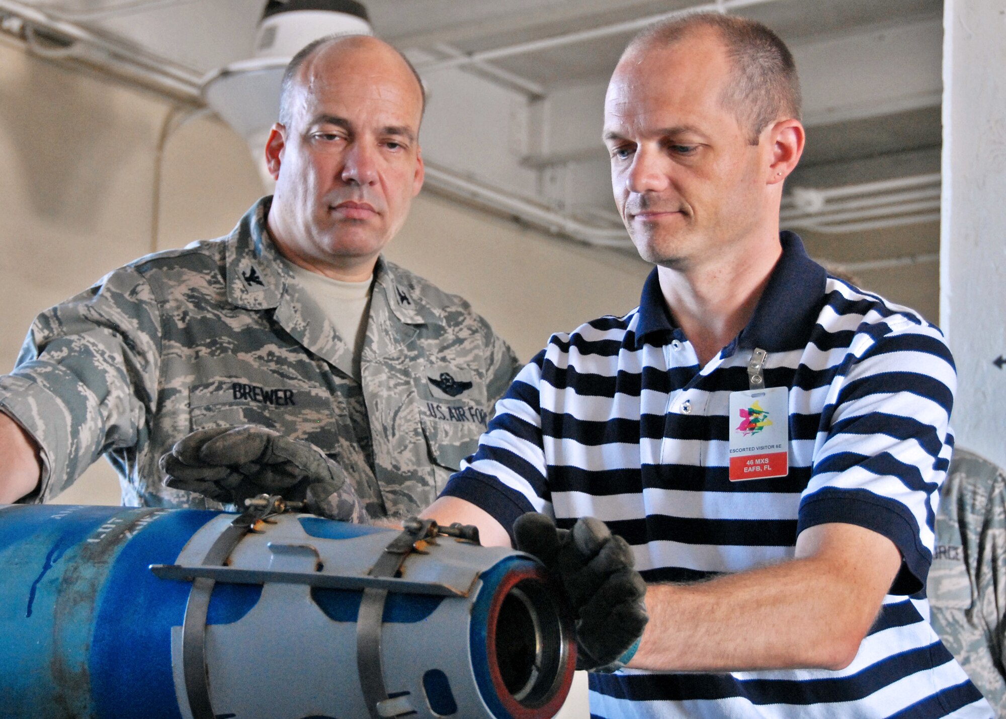 James LaFollette, honorary commander for the 46th Test Wing, begins the process of building a Guided Bomb Unit-38 as Col. Michael Brewer, 46th Test Wing commander, watches Sept. 22 at Eglin Air Force Base, Fla.  The 46th honorary commanders toured many of the 46 TW facilities and received hands-on demonstrations for many of the jobs of the 46th maintainers.  (U.S. Air Force photo/Samuel King Jr.)  

