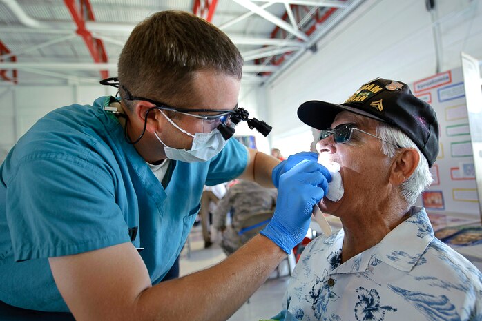NELLIS AIR FORCE BASE, Nev.-- Capt. Trent Buttars, 99th Dental Squadron resident dentist, performs an oral exam on retired U.S. Army Master Sgt. James Murphy during the 2010 Retiree Appreciation Day Sept. 25. More than 800 attendees received health screenings throughout the day at the Thunderbird hangar. (U.S. Air Force photo by Lawrence Crespo)