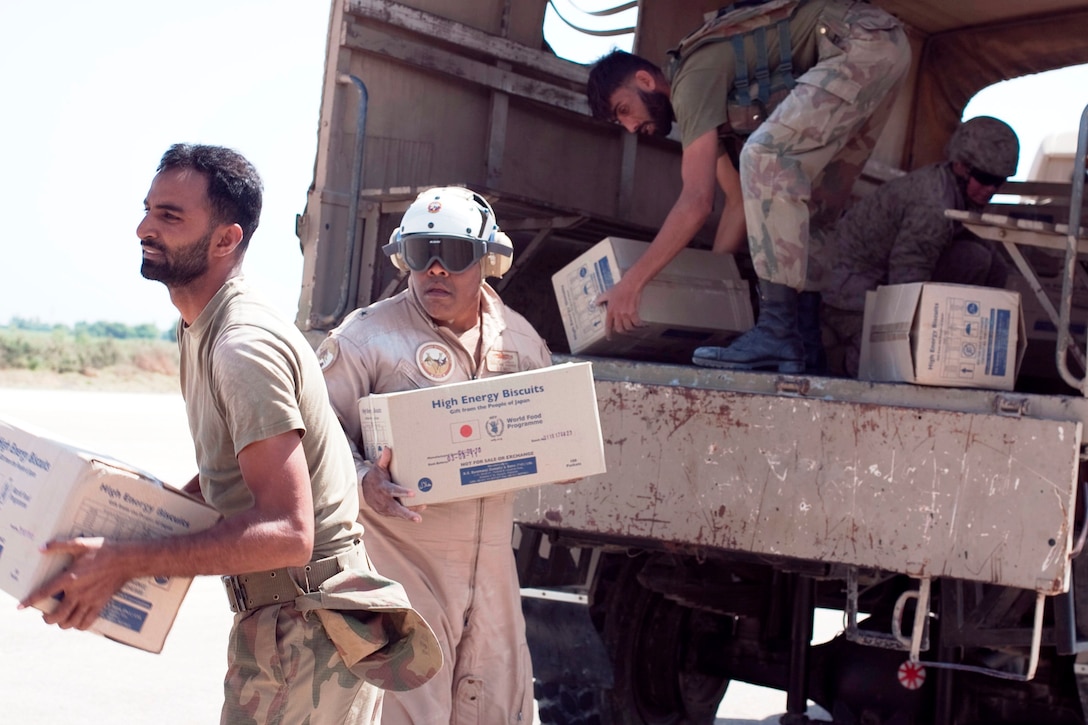 Rear Admiral Sinclair Harris, commanding officer of the U.S. military’s Task Force South, Pakistan assists Pakistani soldiers with the loading of relief supplies on to a Marine Sea Knight from HMM-165 (REIN), 15th Marine Expeditionary Unit during relief operations in the southern province of Sindh, Pakistan.