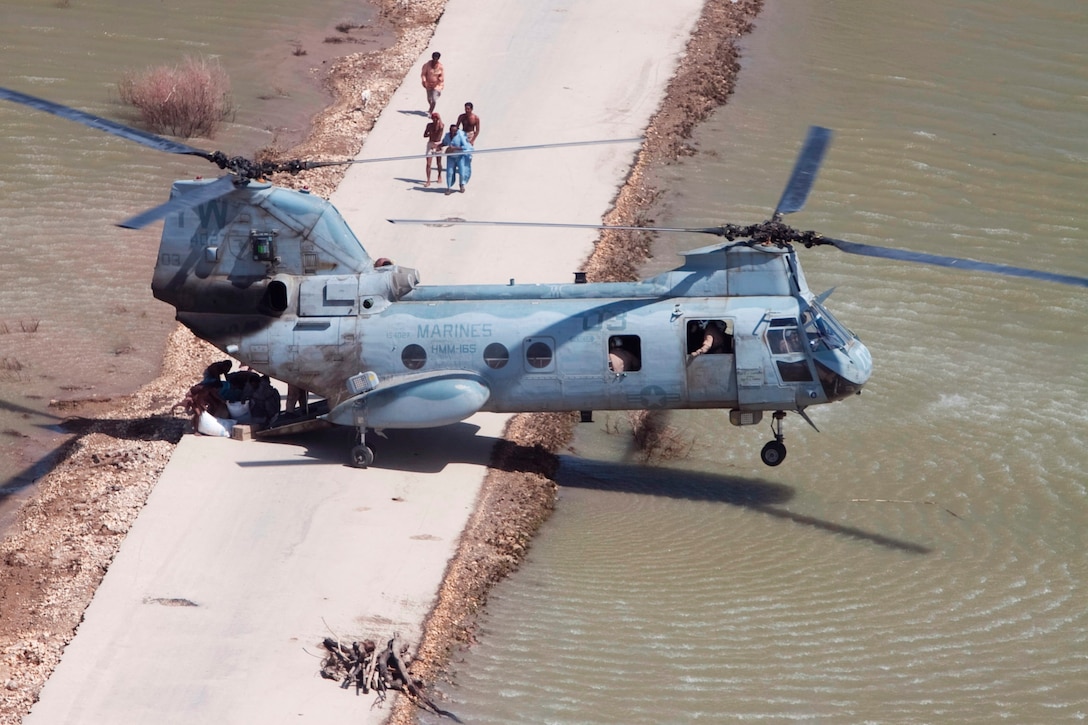 A Marine Sea Knight from HMM-165 (REIN), 15th Marine Expeditionary Unit performs a main mount hover on a road too narrow for a full landing in the southern province of Sindh, Pakistan to deliver relief supplies during humanitarian assistance operations.
