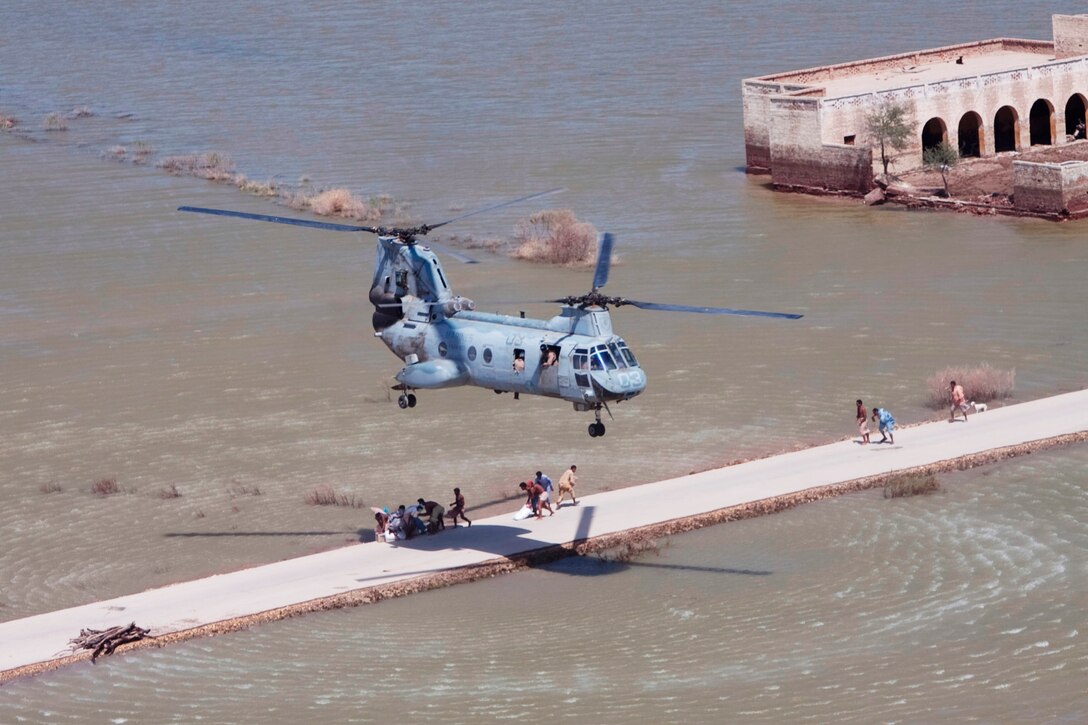Pakistani flood victims rush to receive relief supplies dropped from a Marine Sea Knight from HMM-165 (REIN), 15th Marine Expeditionary Unit in the southern province of Sindh, Pakistan during humanitarian assistance operations.