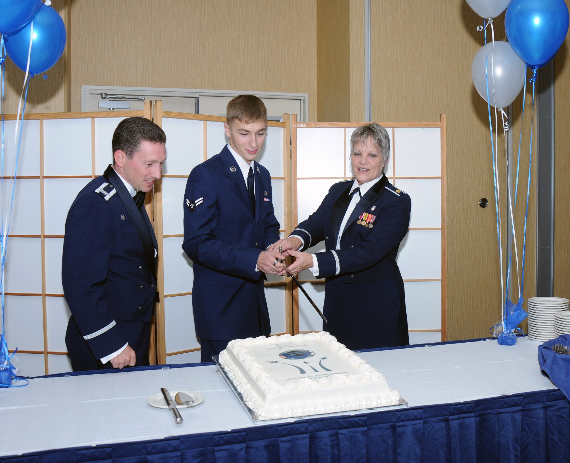Col. Michael Rothstein, 35th Fighter Wing commander, Airman 1st Class Michael Grajek from the 35th Maintenance Squadron, and Maj. Kathleen Martin from the 35th Surgical Operations Squadron, prepare to cut the official cake commemorating the Air Force’s 63rd anniversary during Misawa Air Base, Japan Air Force Ball, Sept. 25, 2010.  Tradition dictates the individuals with the most and least time-in-service join the commander to cut the cake. (U.S. Navy photo by Mass Communication Specialist 2nd Class Matthew M. Bradley /Released)