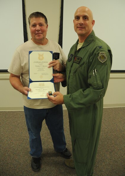 Tommy Reaves receives his certificate for 30 years of federal civilian service from  Col. Andy Comtois, 919th Special Operations Wing vice commander. The awards were presented at the 919th SOW’s civilian commander’s call Sept. 22. (U.S. Air Force photo/Staff Sgt. Jonathan McCallum)