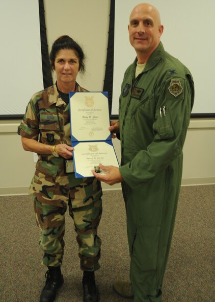 Senior Master Sgt. Betsy Gunn receives her certificate for 30 years of federal civilian service from  Col. Andy Comtois, 919th Special Operations Wing vice commander. The awards were presented at the 919th SOW’s civilian commander’s call Sept. 22. (U.S. Air Force photo/Staff Sgt. Jonathan McCallum)