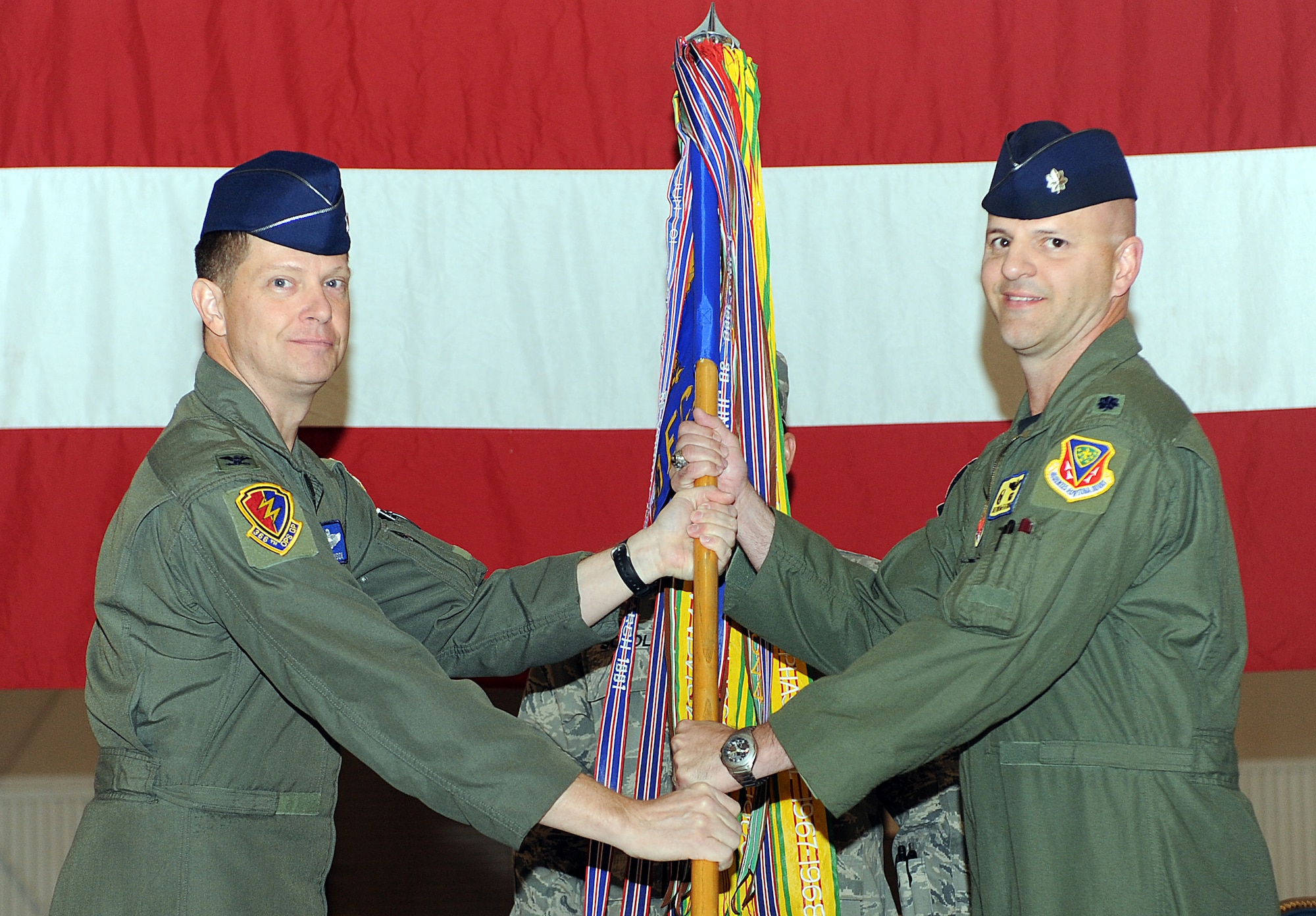 MOUNTAIN HOME AIR FORCE BASE, Idaho – Col. Kyle Robinson, 366th Operations Group commander, passes the guidon to Lt. Col. Donald McFatridge, 390th Electronic Combat Squadron commander during a re-designation ceremony in hangar 1331, Sept 27. The 390th ECS is responsible for training aircrews to operate the EA-6B Prowler, and started the transition to the E/F-18G Growler.  Today the Airmen of the 390th ECS deploy with U.S. Navy squadrons to hotspots around the globe.(U.S. Air Force photo by Senior Airman Debbie Lockhart)