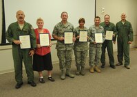 Displaying certificates honoring their 20 years of federal civilian service (from left) are: Lt. Col. Stanton Barth; Kimberly Hernandez; Master Sgt. Marion Lollis Jr.;  Master Sgt. Theresa Mioduszewski; Chief Master Sgt. David Simmet; and Lt. Col. Christopher Snider. With them is Col. Andy Comtois, 919th Special Operations Wing vice commander. The awards were presented at the 919th SOW’s civilian commander’s call Sept. 22. (U.S. Air Force photo/Staff Sgt. Jonathan McCallum)