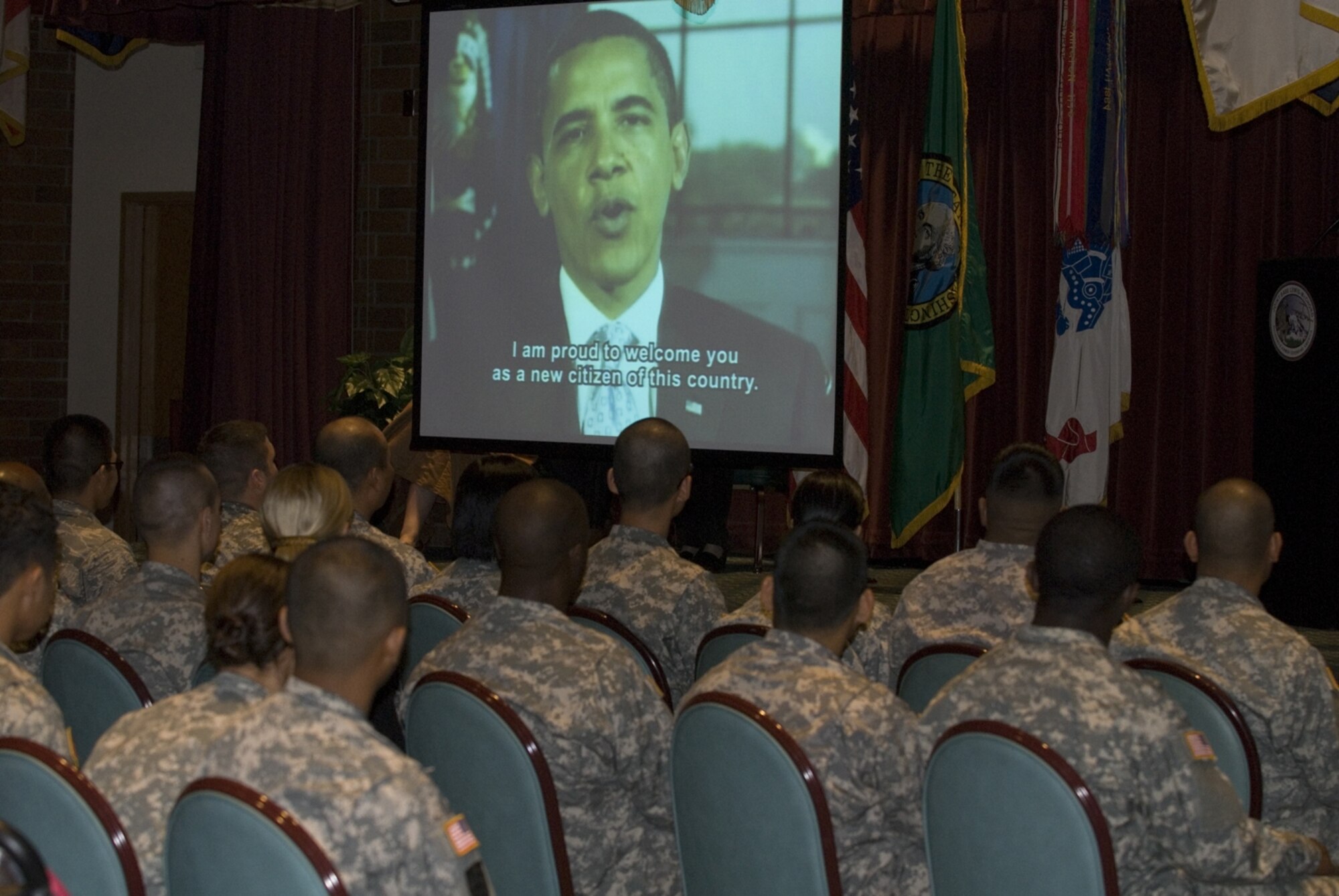 Servicemembers watch a congratulatory video message from President Barack Obama at the Annual Naturalization Ceremony Sept. 17 at the McChord Field Co-Located Club, Wash. (U.S. Army Photo/Pfc. Shakia M. Howard)