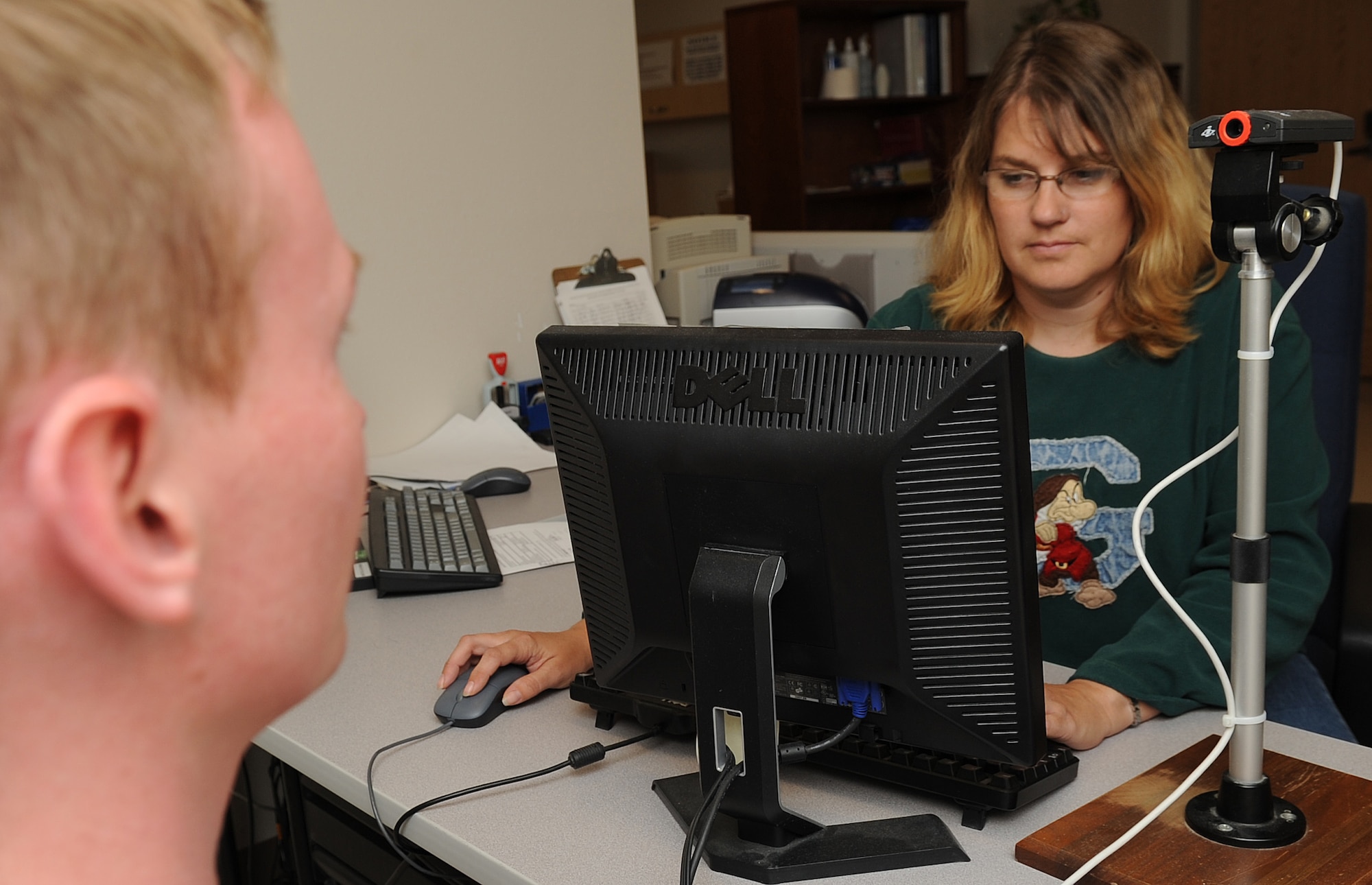 MOUNTAIN HOME AIR FORCE BASE, Idaho -- Angie Drewicz, 366th Security Forces Squadron visitor control center assistant, takes a Restricted Area Badge photo at the Visitor Control Center Sep 23. A recent Department of Defense directive changed the way visitors are granted access to military installations and will take effect on Oct. 11. (U.S. Air Force photo by Senior Airman Roy Lynch)