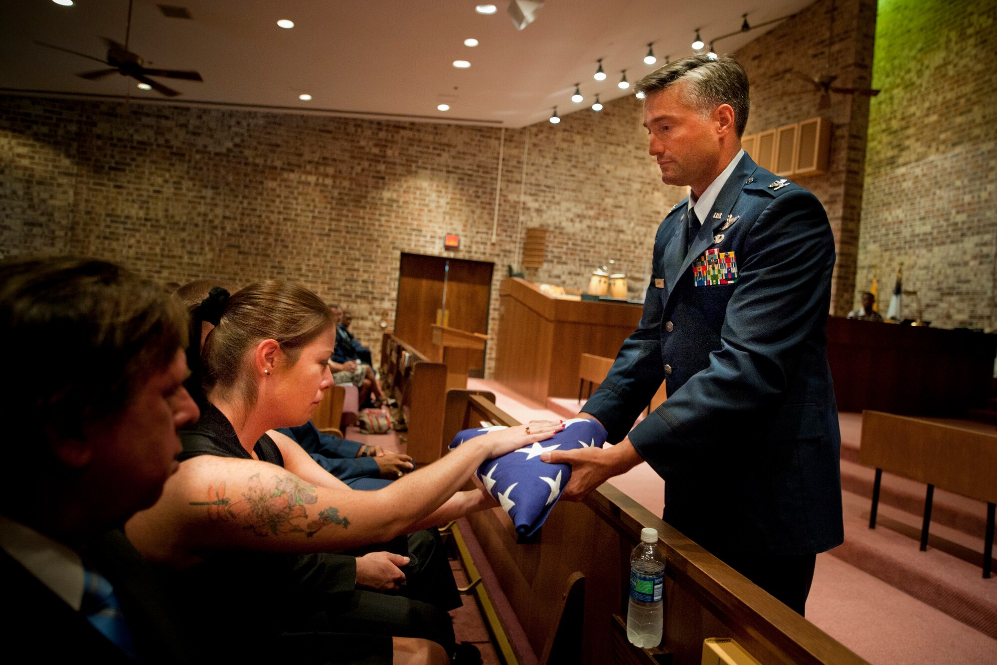 MOODY AIR FORCE BASE, Ga. -- Col. William DeMaso, 23rd Wing vice commander, presents the American flag to Jennifer Magdolen, sister of Staff Sgt. Katherine Fisher, during a memorial service Sept. 22 at the Base Chapel. Sergeant Fisher joined the Air Force in 2000. During her assignment at Moody, she deployed to Balad Air Base, Iraq, as a maintenance scheduler where she earned an Air Force Achievement Medal. (U.S. Air Force photo/Senior Airman Jamal D. Sutter)