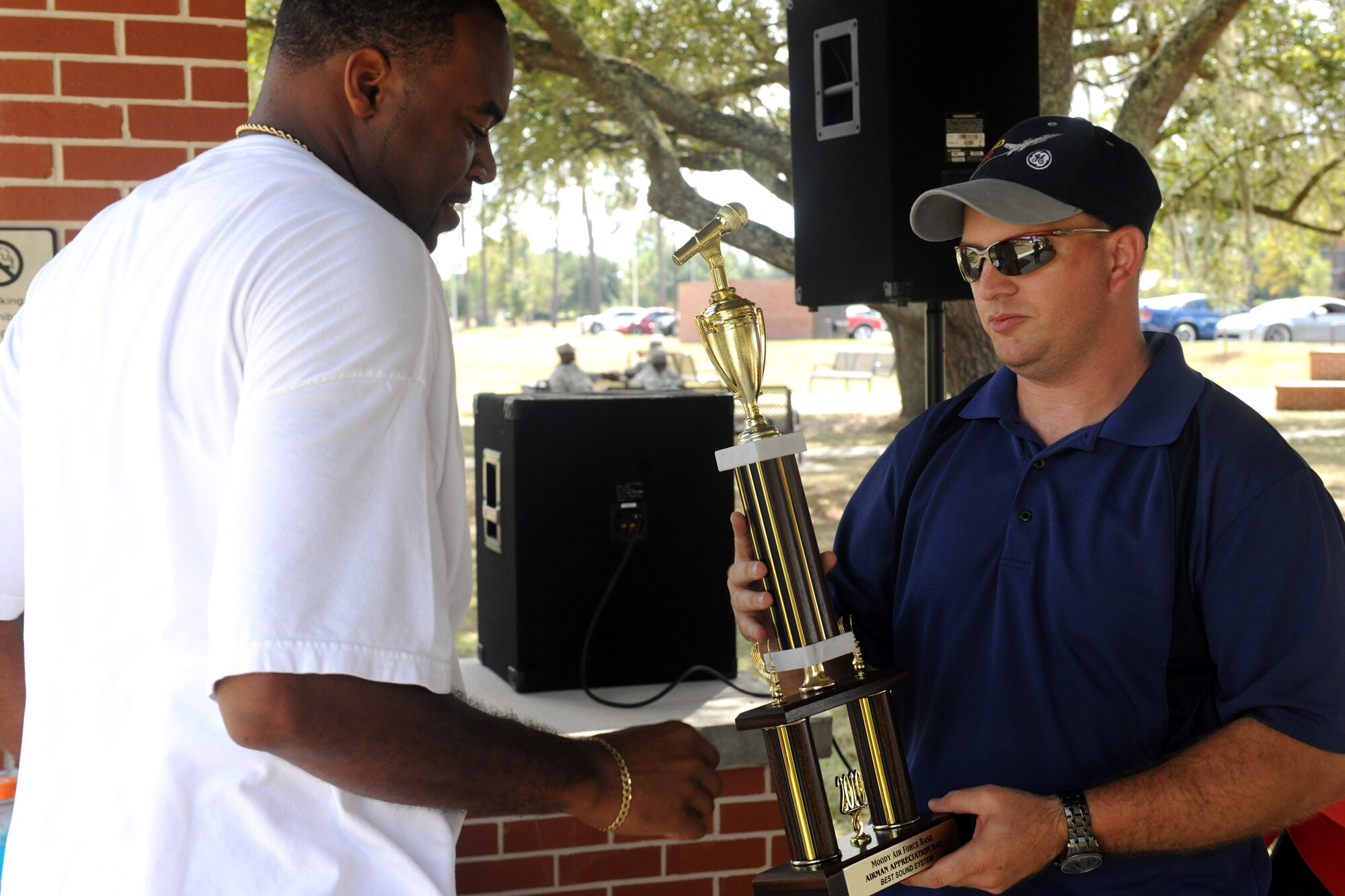 MOODY AIR FORCE BASE, Ga. -- Senior Airman Mackel Stafford, 74th Aircraft Maintenance Unit, receives the award for best audio system from Master Sgt. Michael Dunblazier, 23rd Logistics Readiness Squadron fuels compliance and environmental section chief, during Airman Appreciation Day here Sept. 24. There were three competitions for vehicles including best motorcycle, best audio system and best overall vehicle. (U.S. Air Force photo/Airman 1st Class Benjamin Wiseman