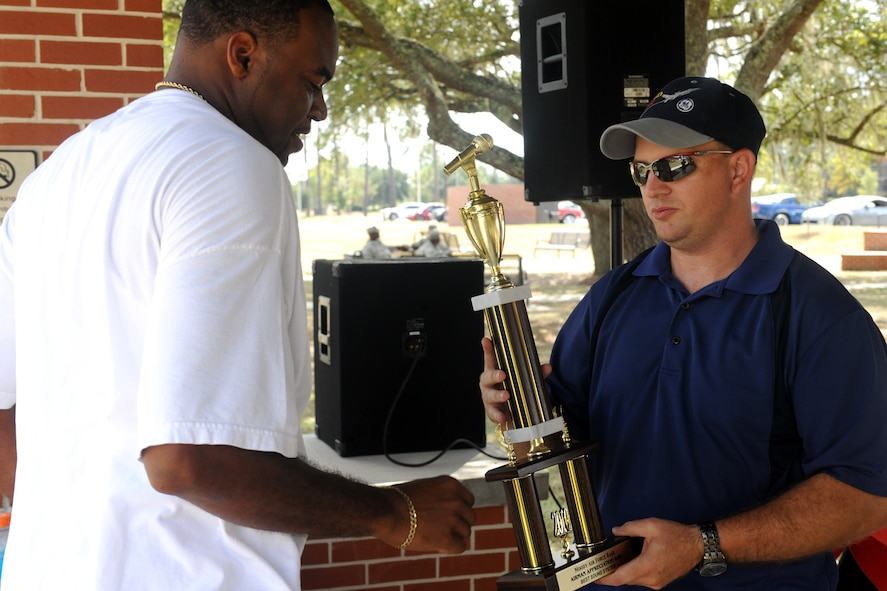 MOODY AIR FORCE BASE, Ga. -- Senior Airman Mackel Stafford, 74th Aircraft Maintenance Unit, receives the award for best audio system from Master Sgt. Michael Dunblazier, 23rd Logistics Readiness Squadron fuels compliance and environmental section chief, during Airman Appreciation Day here Sept. 24. There were three competitions for vehicles including best motorcycle, best audio system and best overall vehicle. (U.S. Air Force photo/Airman 1st Class Benjamin Wiseman