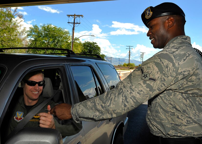 HOLLOMAN AIR FORCE BASE, N.M. -- Airman Briand Williams, 49th Security Forces Squadron, checks the identification card of Maj. Chris Bergtholdt, 8th Fighter Squadron, before giving him access onto the base, Sept. 21, 2010. Security Forces members will be manning the Installation Entry Control Points and search areas during the transition of new Department of the Air Force Police Officers and Security Guards who will continue to secure Holloman, its personnel and resources. (U.S. Air Force photo by Senior Airman Veronica Stamps / Released)