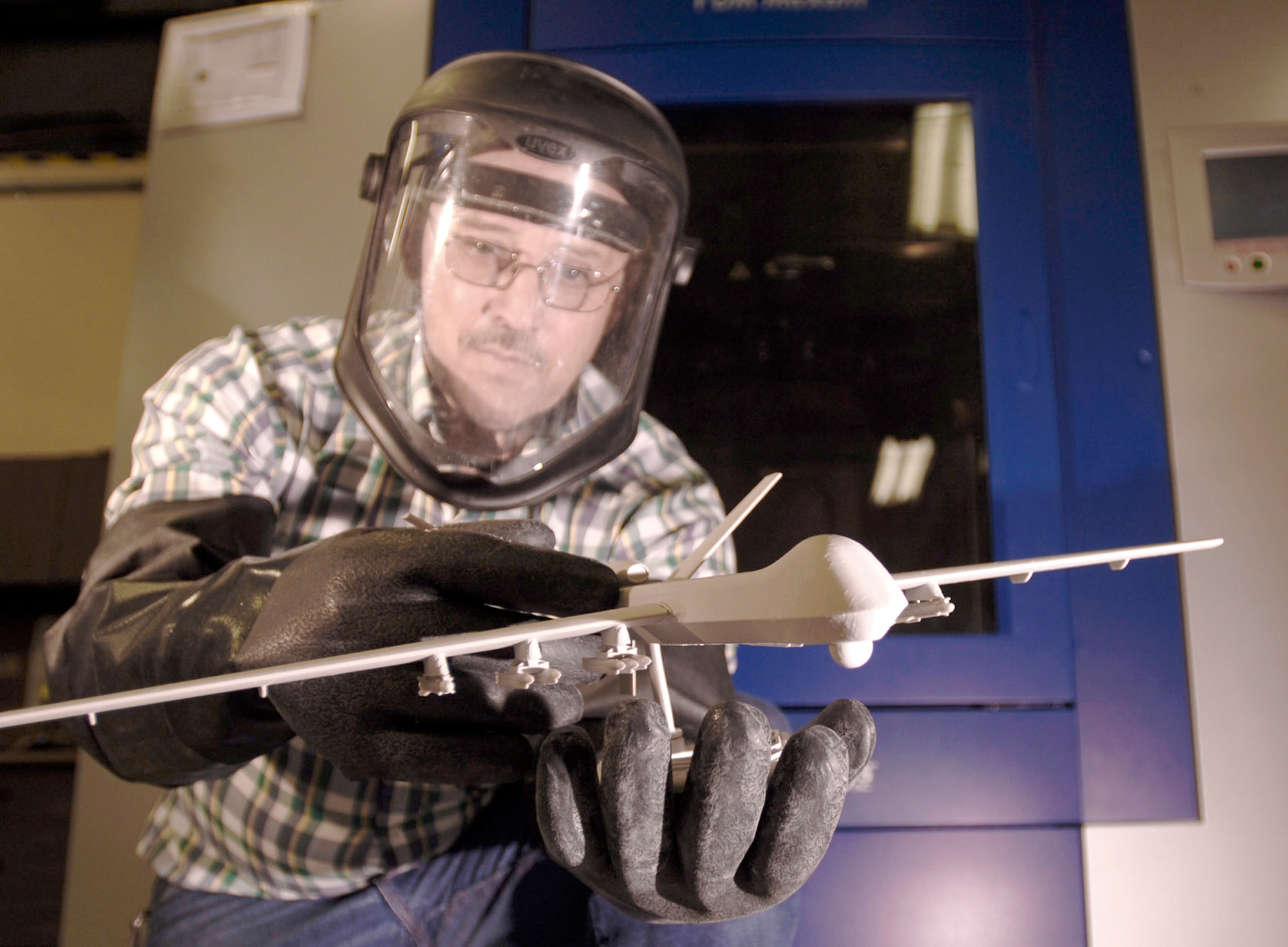 Bud Schmidt holds a model of an unmanned aerial vehicle created by the Fused Deposition Modeler at Sheppard Air Force Base, Texas, July 19, 2008. The FDM was used in conjunction with 3-D laser-scanning equipment purchased through the Productivity Enhancing Capital Investment program to increase the 982nd Maintenance Squadron's trainer production rates by 875 percent. (U.S. Air Force photo/Master Sgt. Cecilio M. Ricardo Jr.)