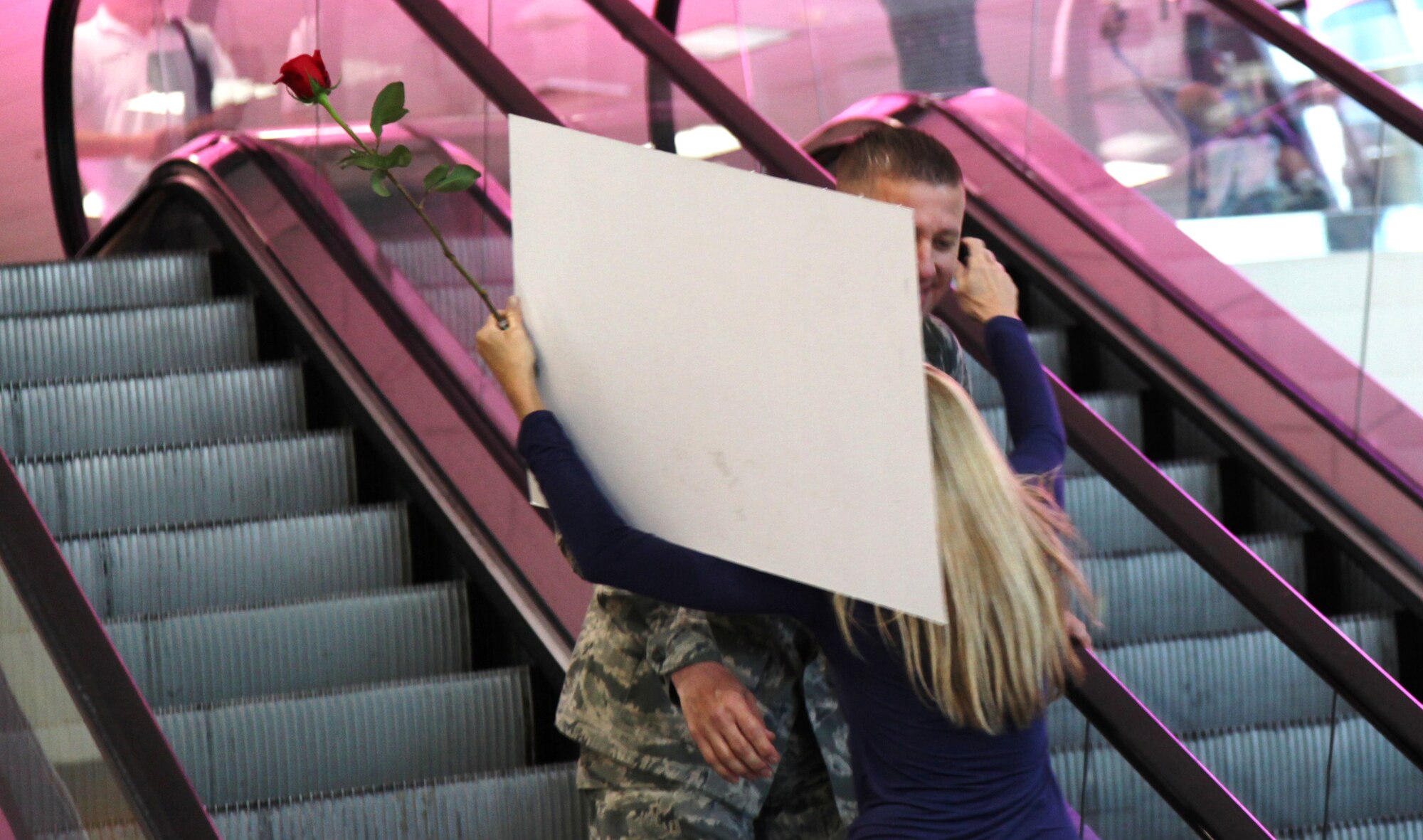 A member of the 940th Wing returning from a six-month deployment is greeted by a loved one on the escaltor at Sacramento International Airport, Sept 21, 2010.  (U.S. Air Force photo/Airman 1st Class Adam Hamar)