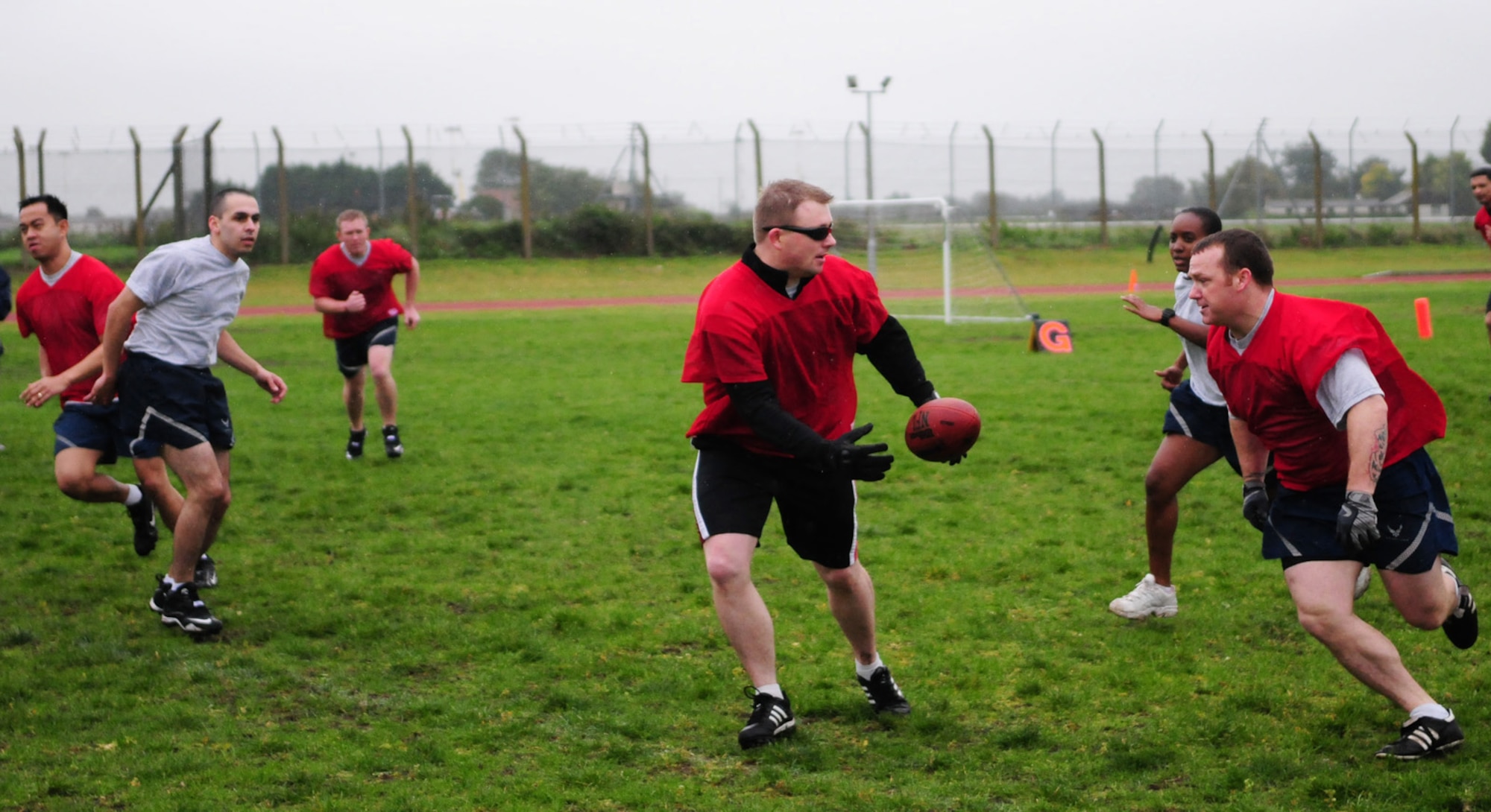 RAF MILDENHALL, England -- A member of the 321st Special Tactics Squadron gets ready to pass the ball to his teammate as the opposition, 100th Communications Squadron, starts to move in on them during a game of Ultimate Football Sept. 24 at Wing Sports Day. Despite being a cold, rainy day, many members of Team Mildenhall turned out to participate in the sporting events. (U.S. Air Force photo/Karen Abeyasekere)