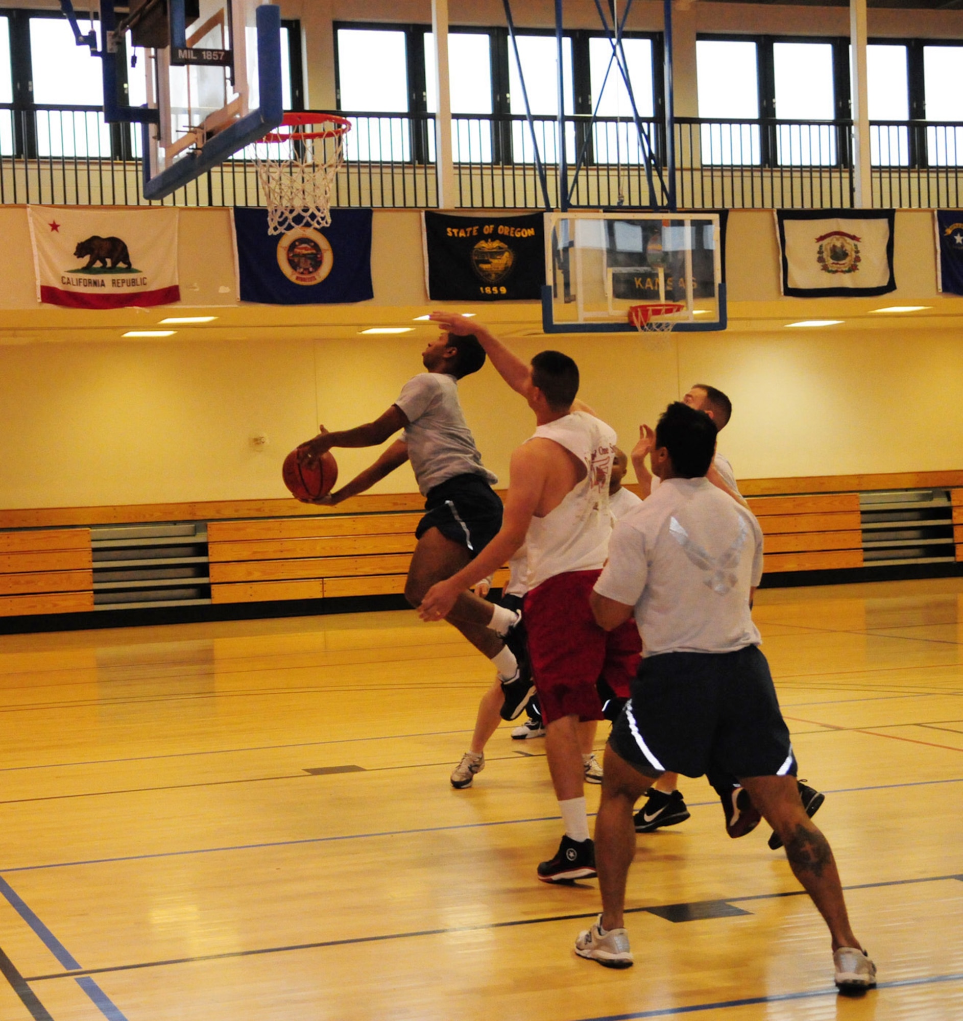 RAF MILDENHALL, England -- Tevell Serrano, left, 488th Intelligence Squadron, takes a jump shot as opposing team members from 100th Air Refueling Wing (Team 2) try and block him at the Wing Sports Day 3-on-3 basketball event at the Hardstand Fitness Center Sept. 24. (U.S. Air Force photo/Karen Abeyasekere)
