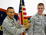 MINOT AIR FORCE BASE, N.D. -- Maj. Brian Rico, 91st Missile Maintenance Squadron commander, promotes Senior Airman Dustin Stringer, 91st MMXS technician and recent below-the-zone recipient here Sept. 20. Airman Stringer is an integral member of Air Force Global Strike Command. (Courtesy photo)